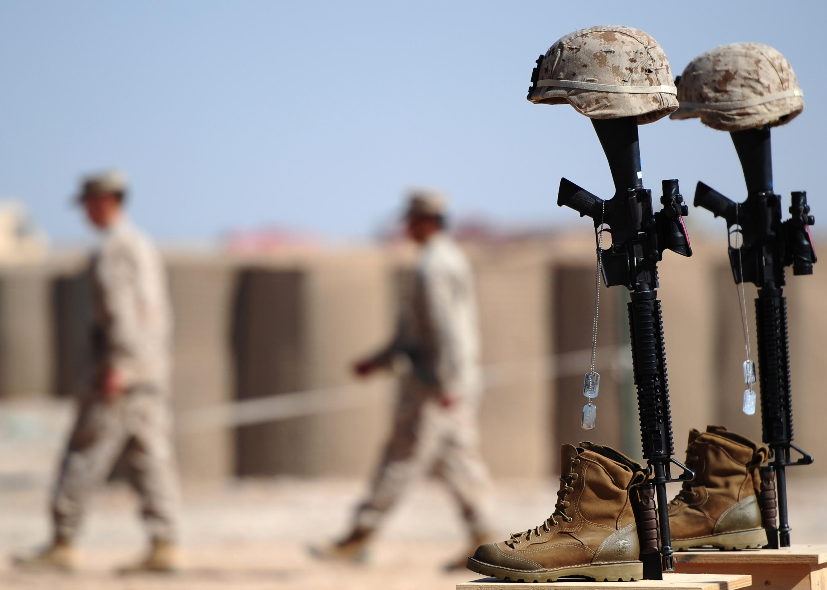 US Marines walking away after adjusting the identification tags on the memorials of soldiers who were killed in Afghanistan.