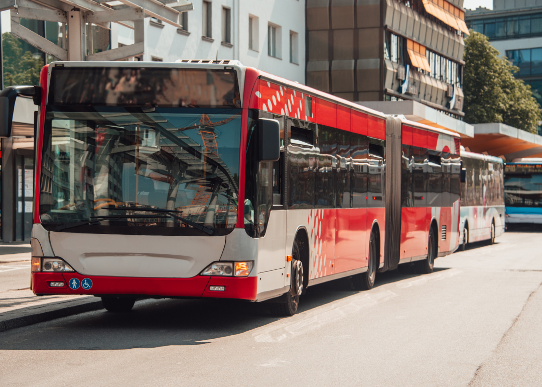 A red bus driving through the city.