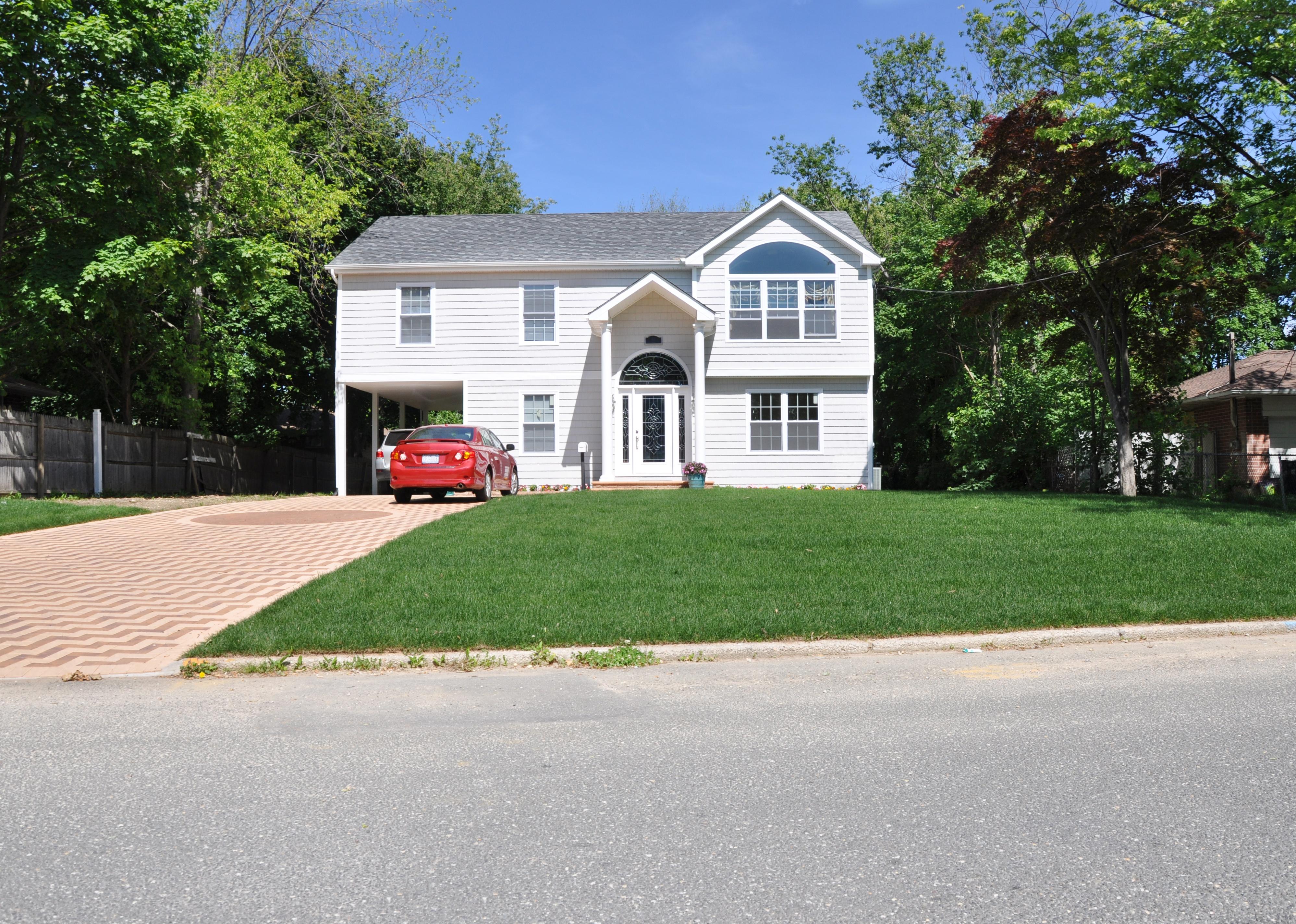 Suburban Ranch home with parked cars in the driveway.