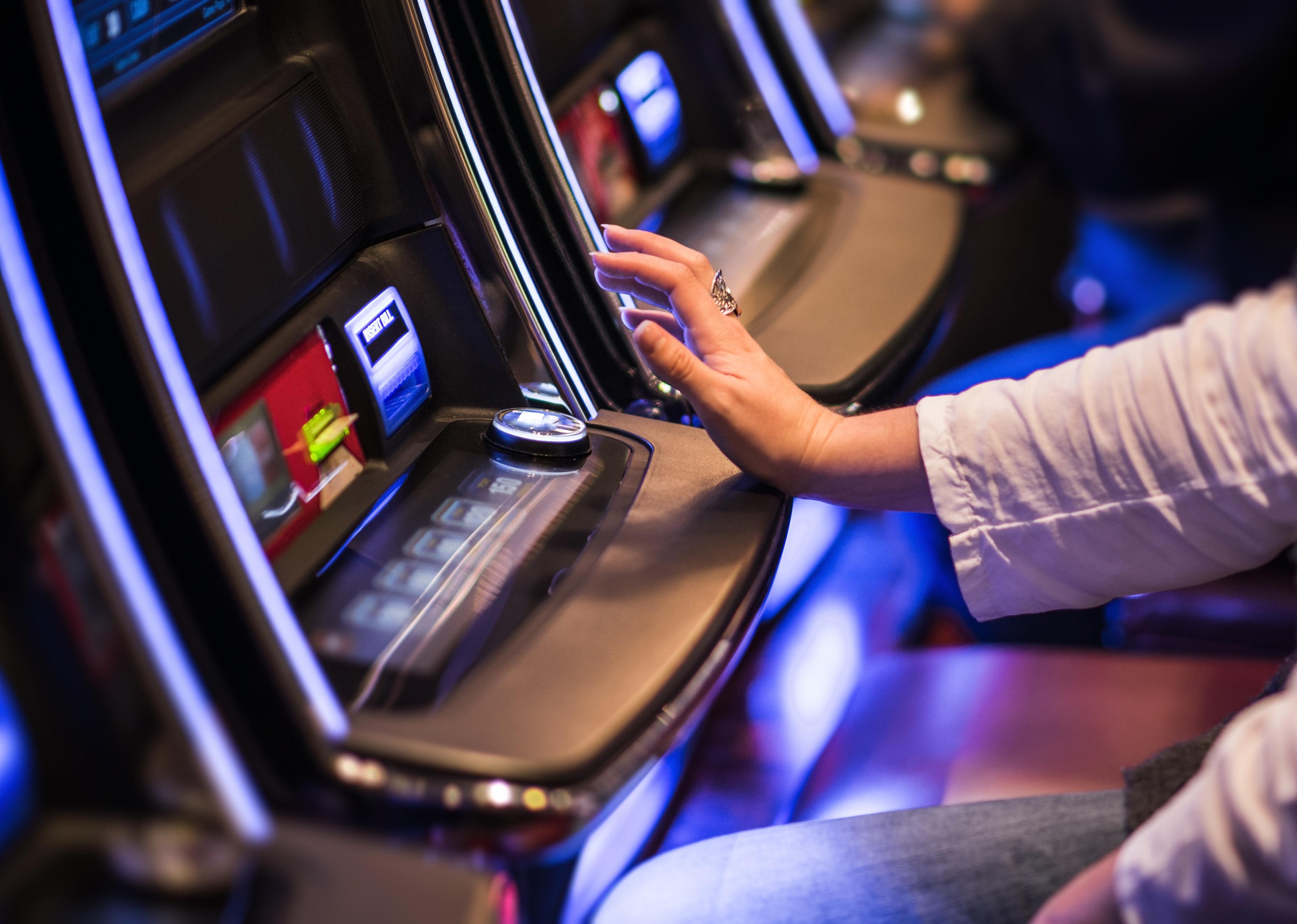 Woman's hand on the button on a video poker game.