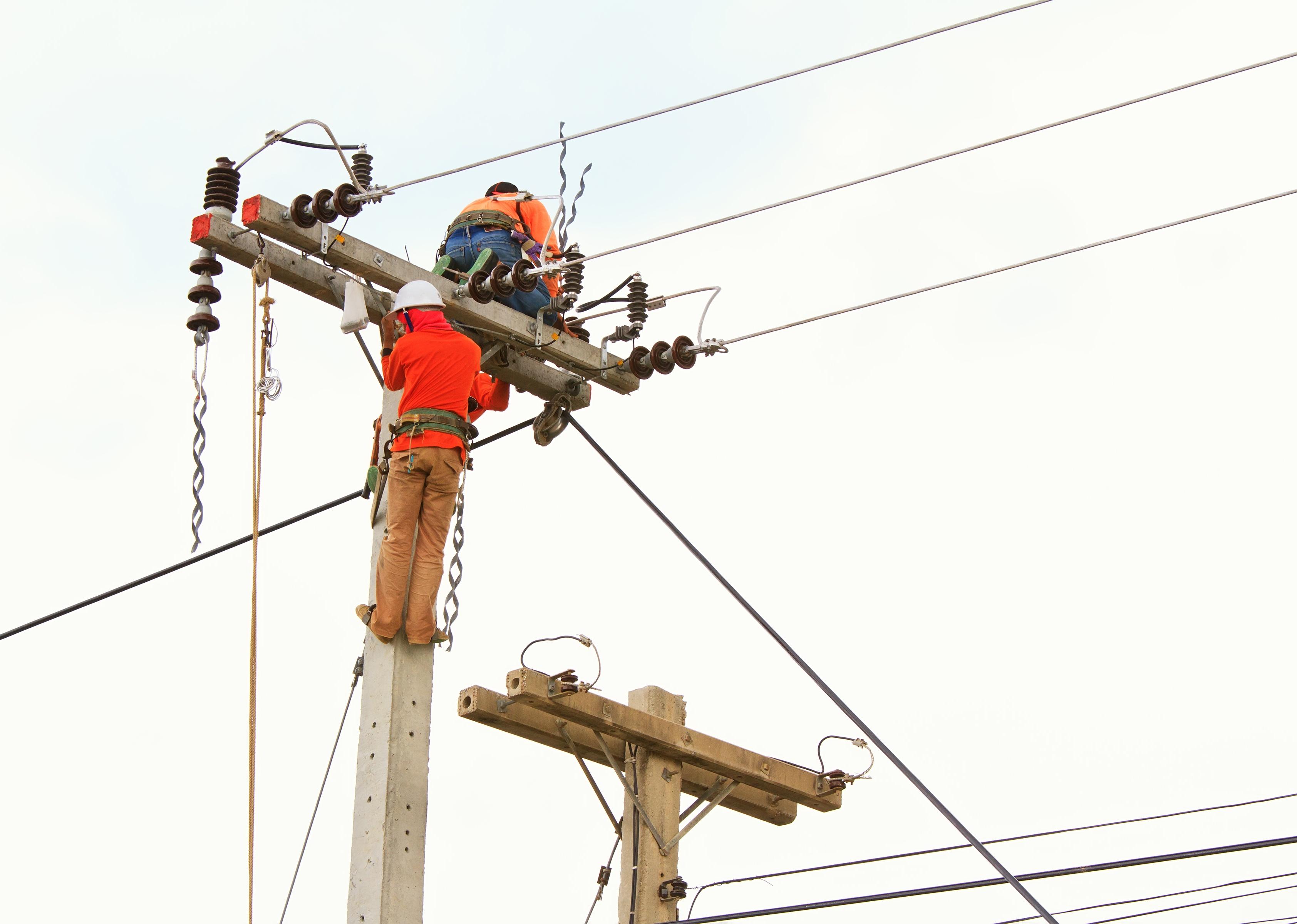 An electrical power utility worker in a bucket fixes the power line.