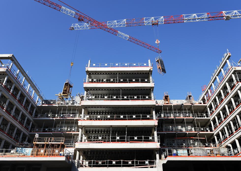 Building site with cranes and blue sky.