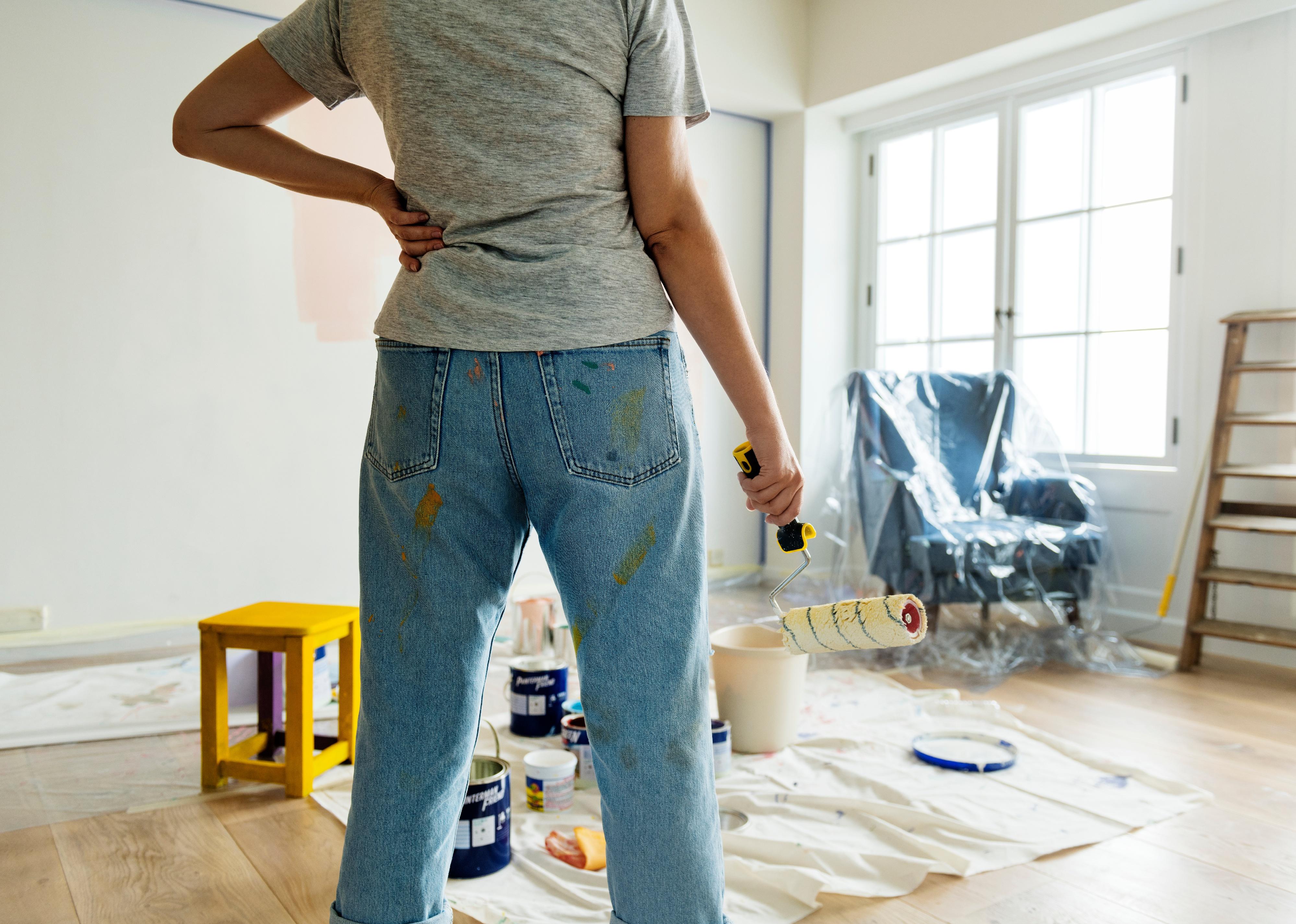 Person holding paint roller looking at room.