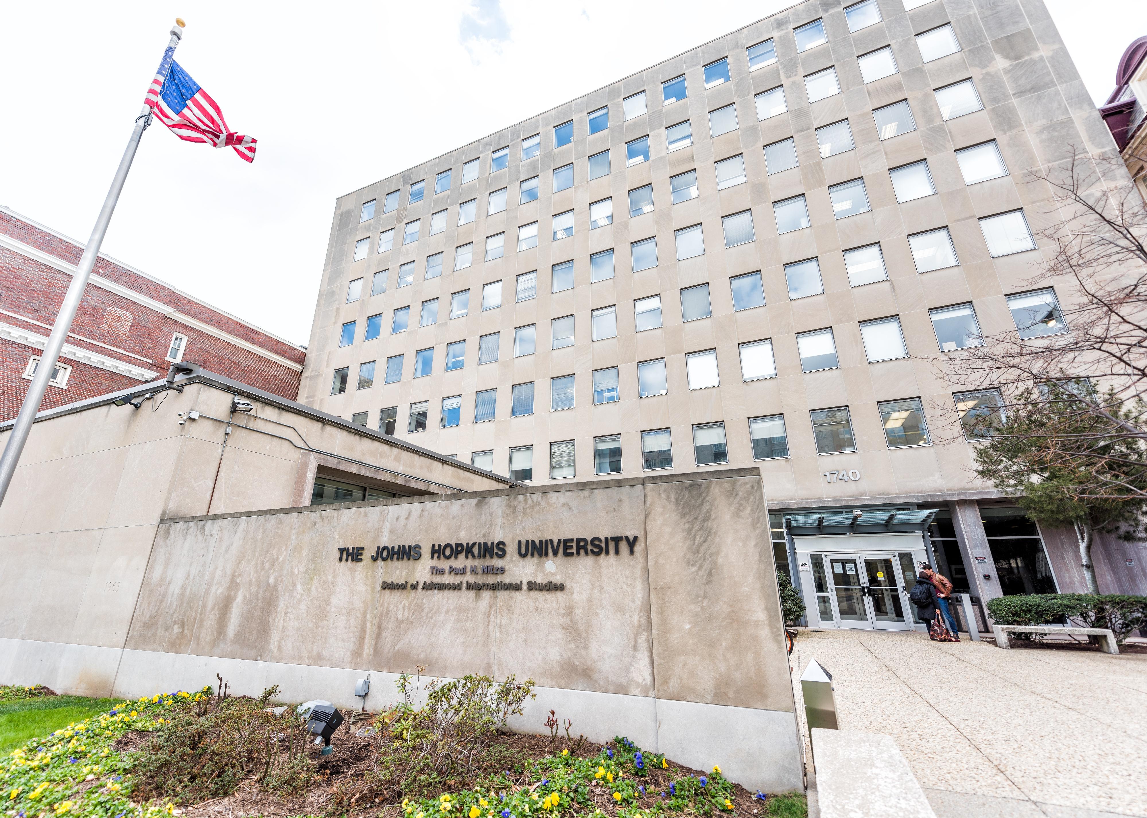 Johns Hopkins University sign, entrance with American flag.