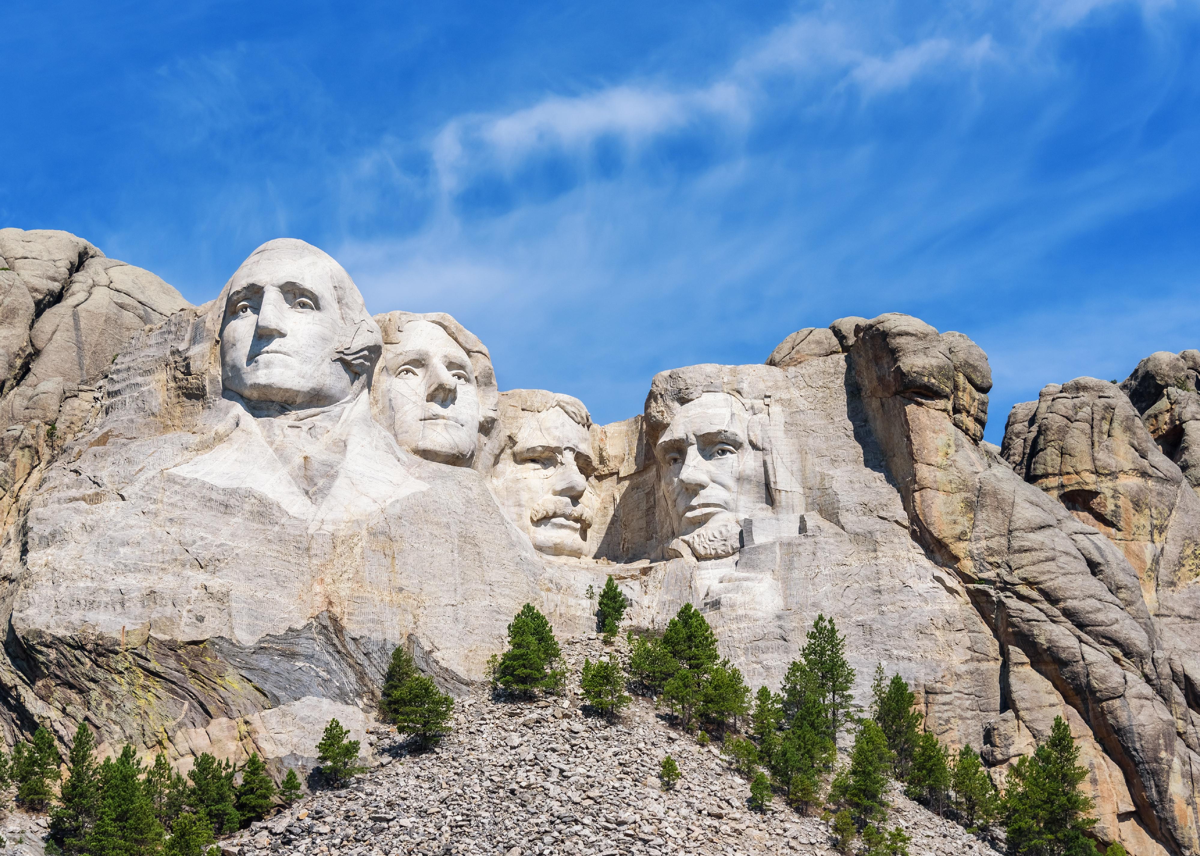 Mount Rushmore with a blue sky in the background.