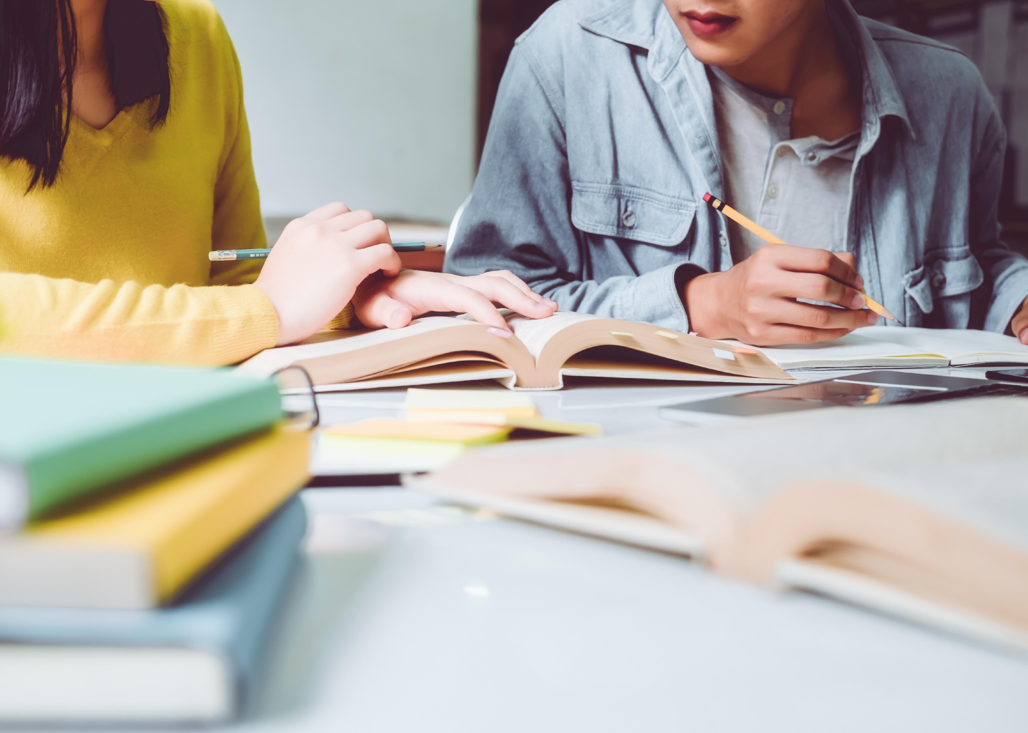 Group of students studying and reading with books in library