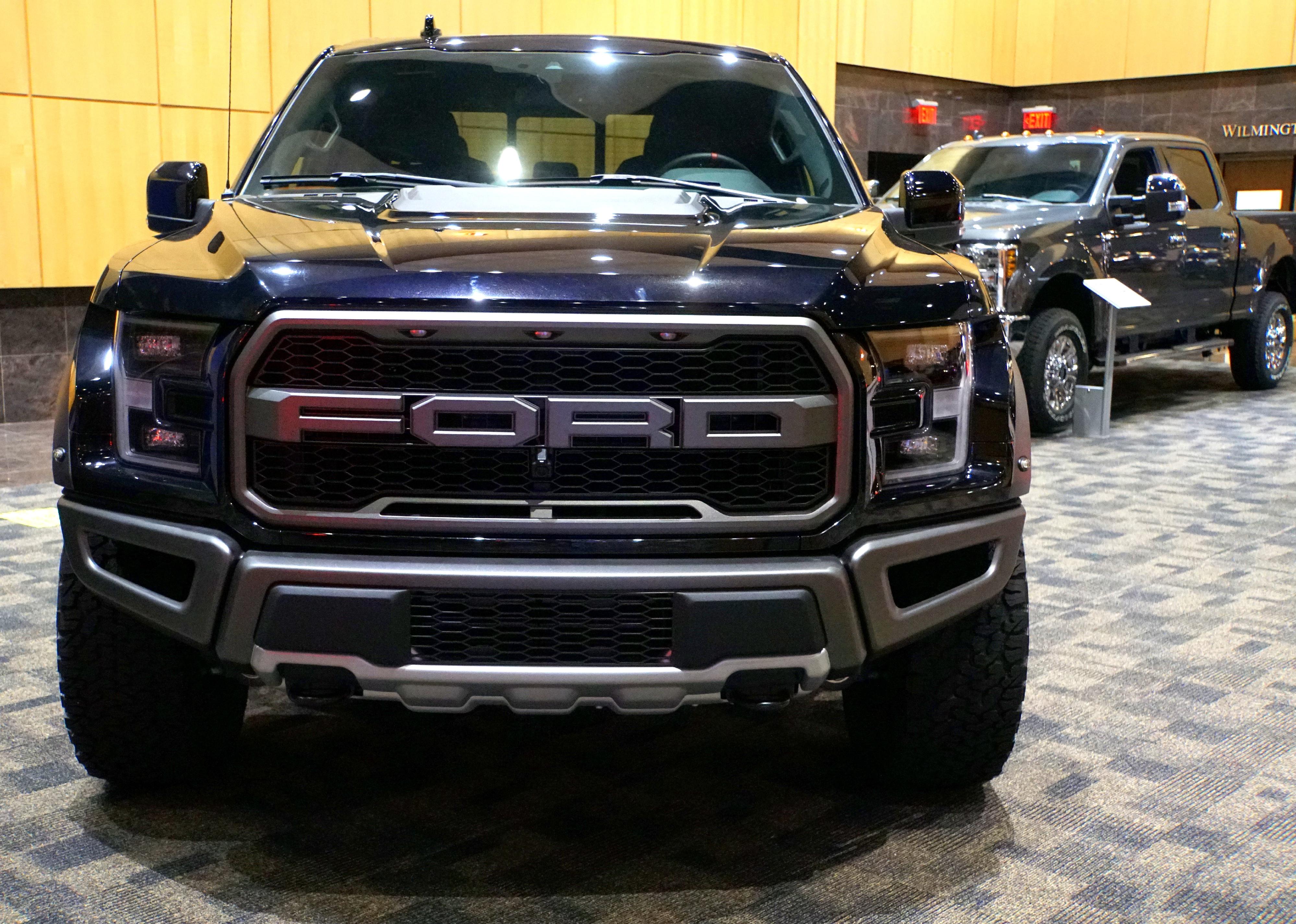 A dark blue Ford F-150 Raptor truck.