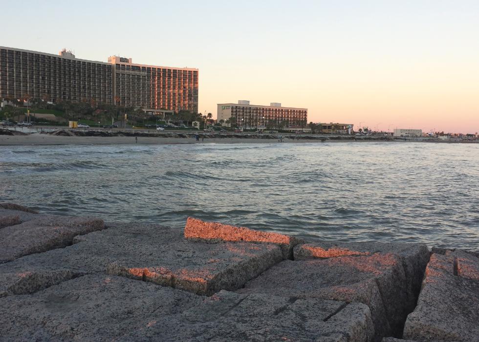 Sunset and buildings along water.