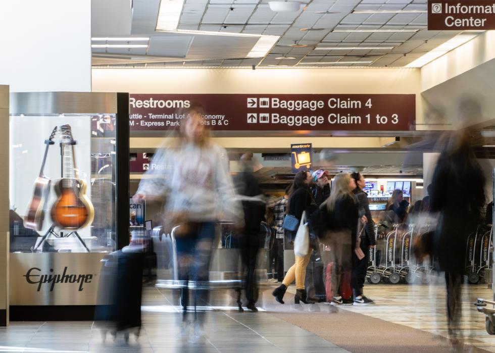 People in motion in the baggage claim area at Nashville International Airport.