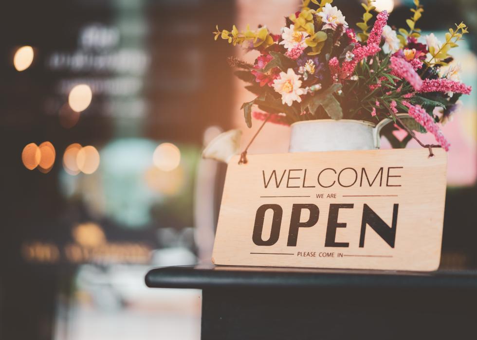 Open sign front of cafe shop with flowers