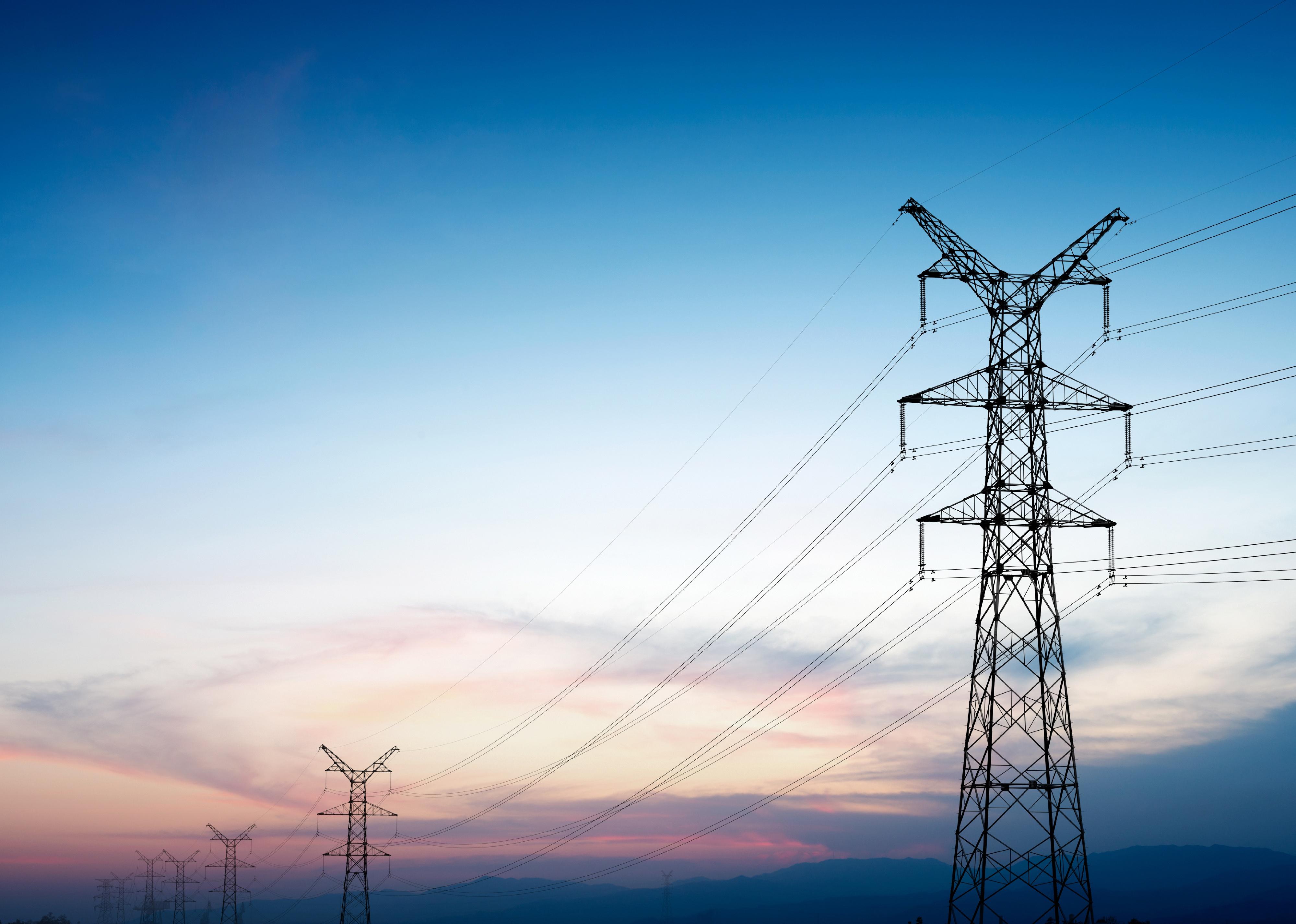 Pylon and transmission power line in sunset.