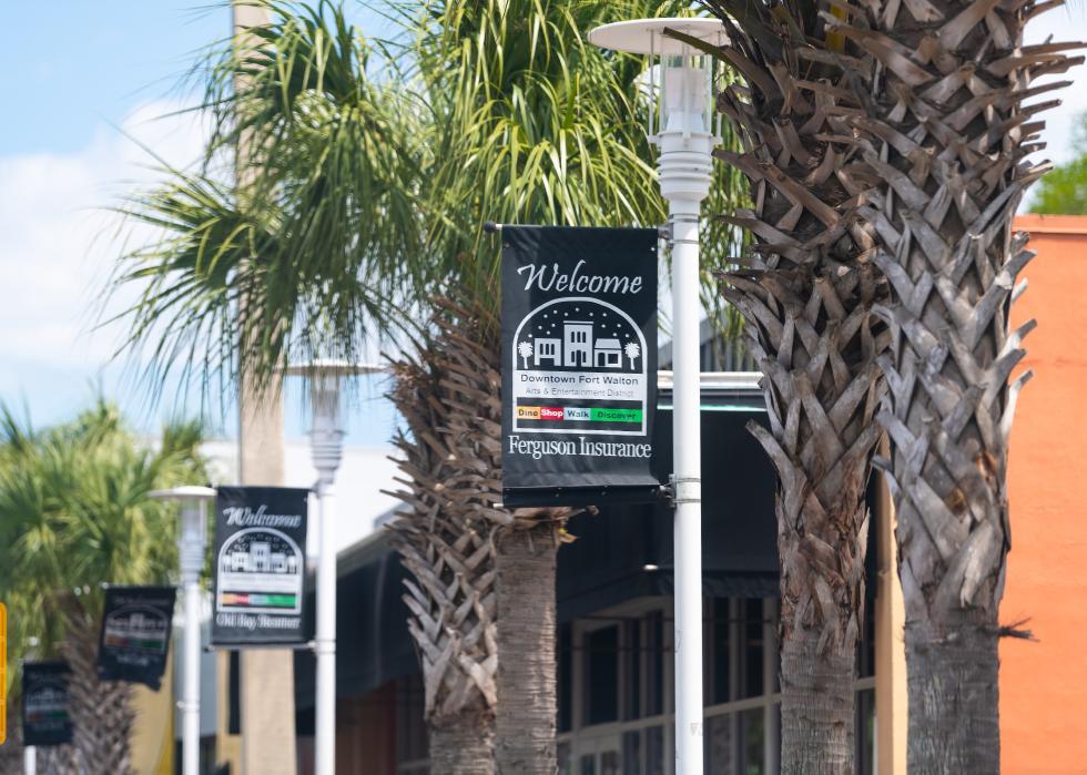 Welcome to Downtown Fort Walton sign on a palm tree.