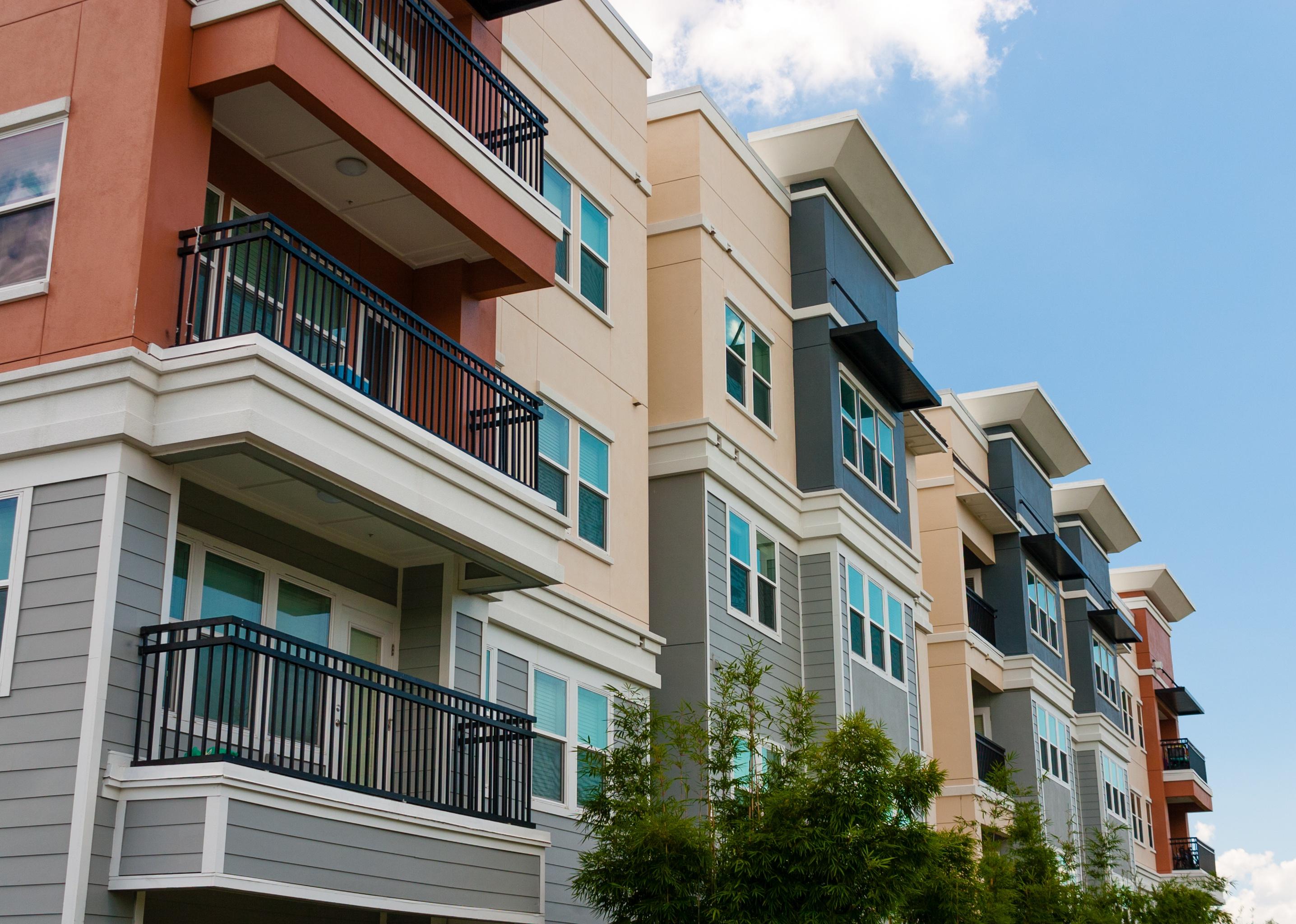 Modern luxury urban apartment building exterior with blue sky.