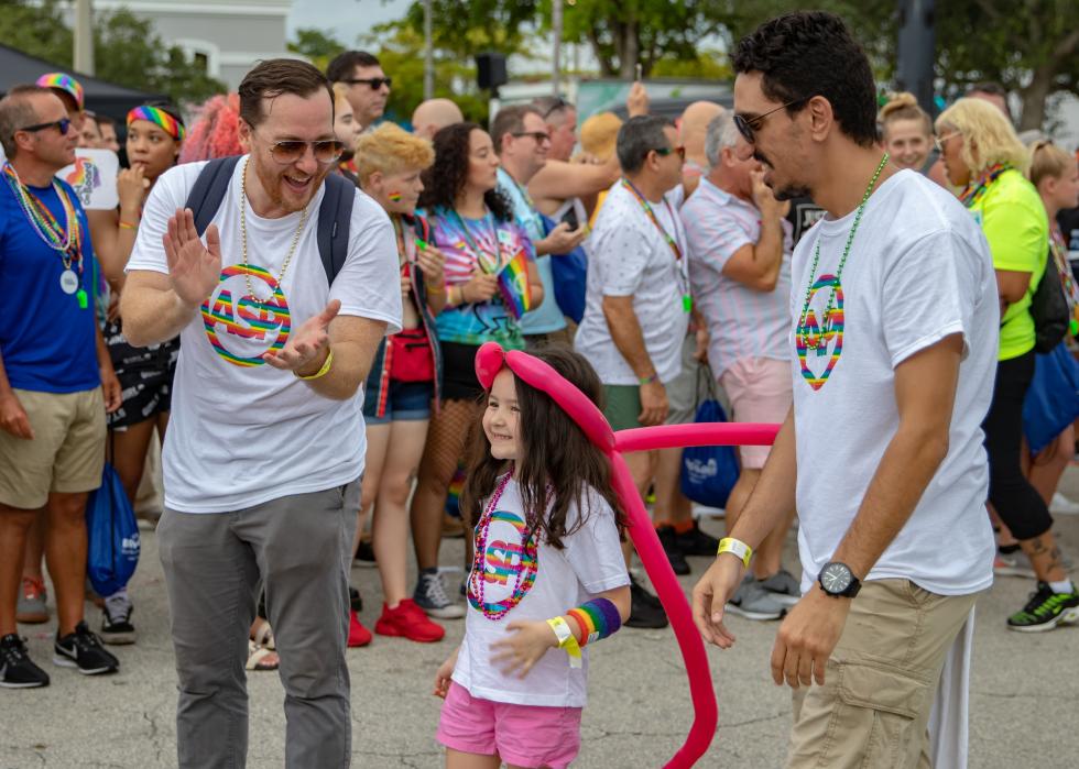 Two men and a little girl walking in a parade