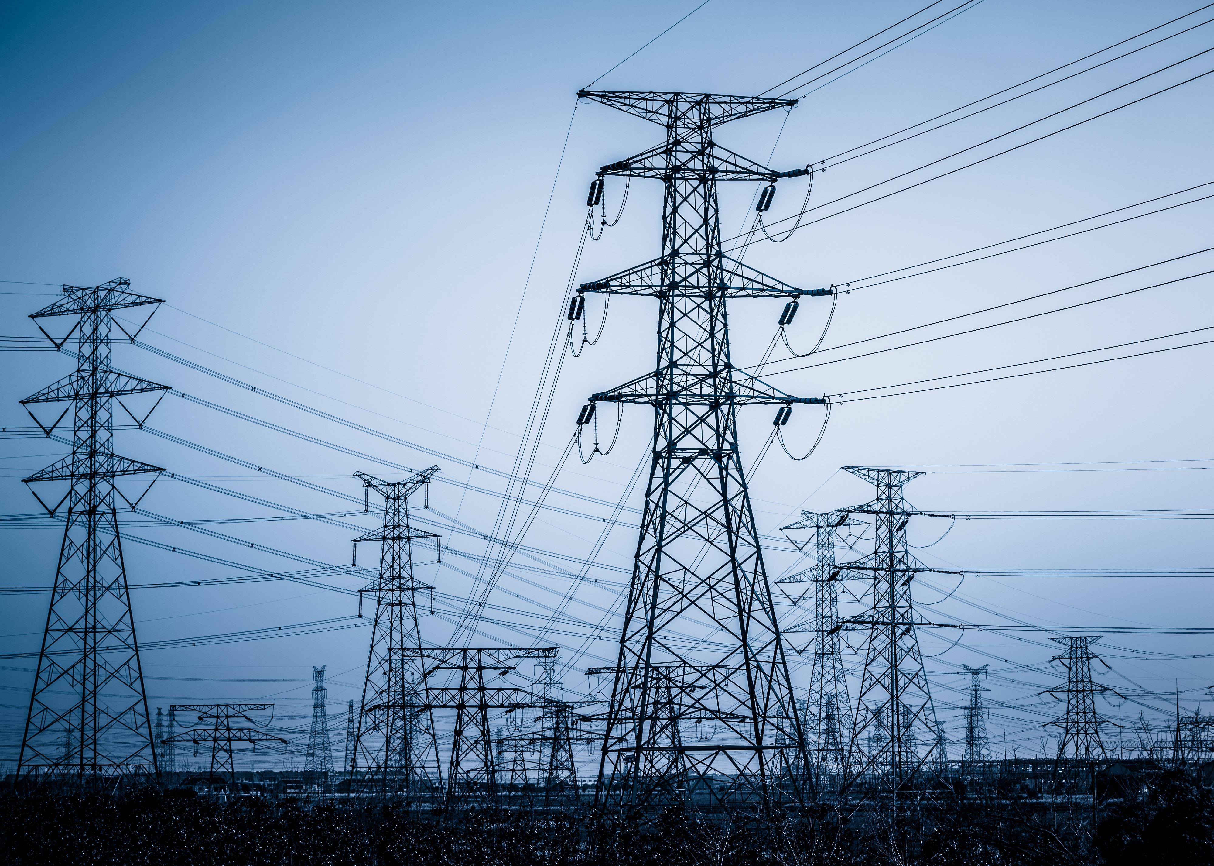 High voltage towers with sky background.