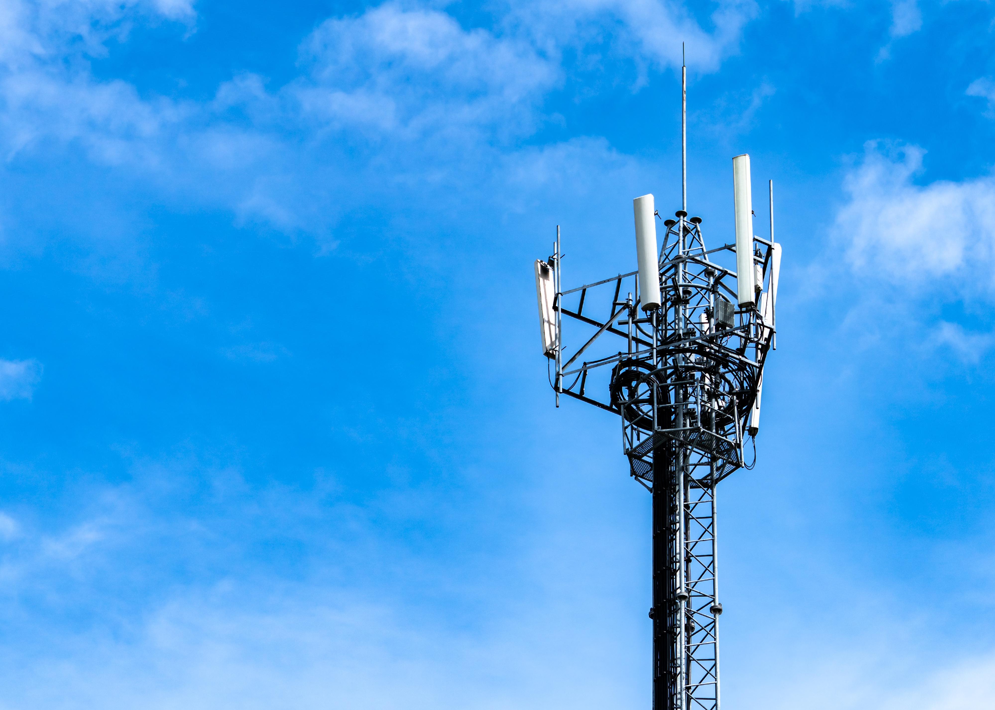 Telecommunication tower with blue sky and white clouds background. 