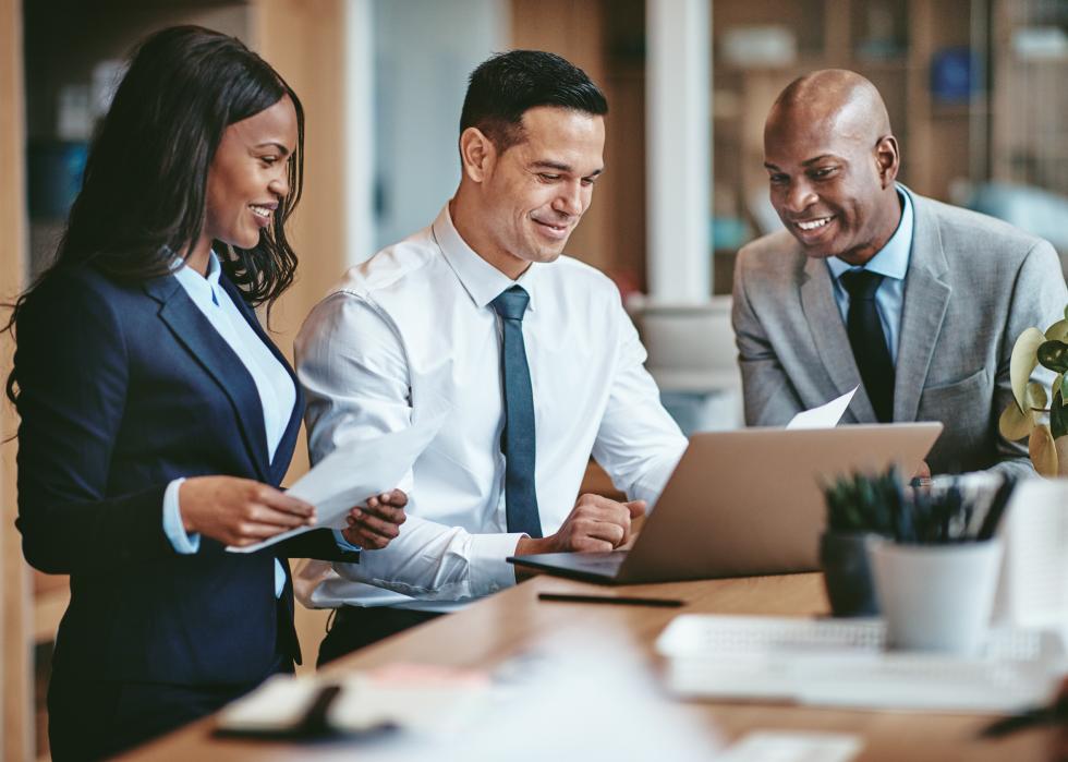 Smiling group of businesspeople going over paperwork together