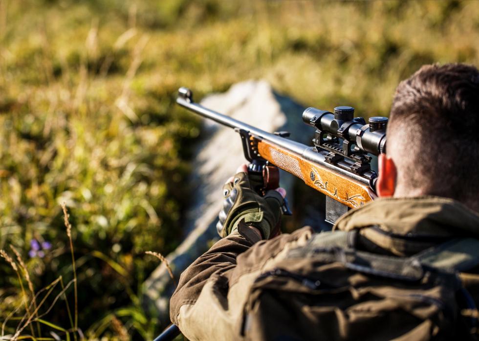 Hunter with rifle aimed forward.