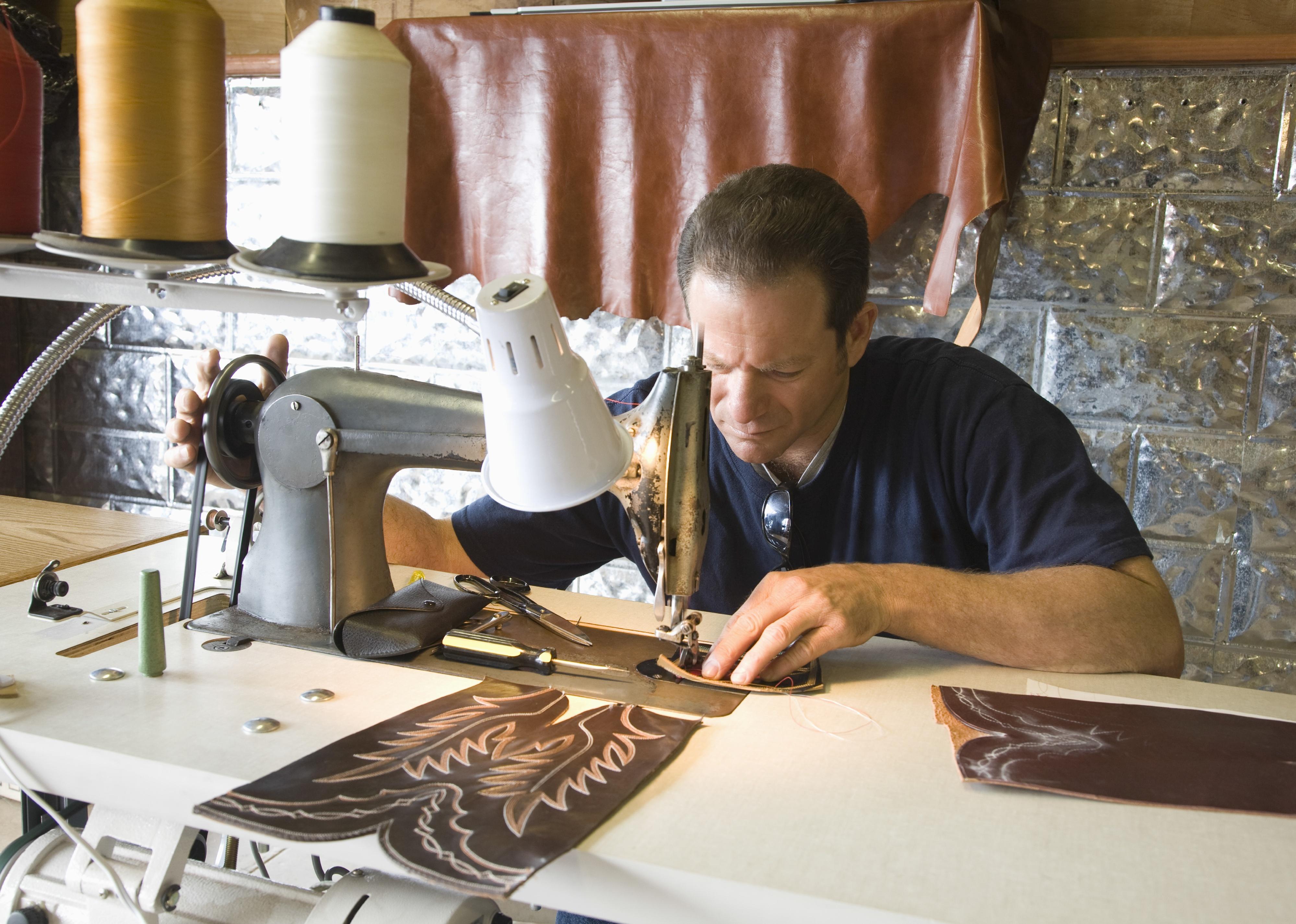 Person working at a traditional shoemaker workshop.