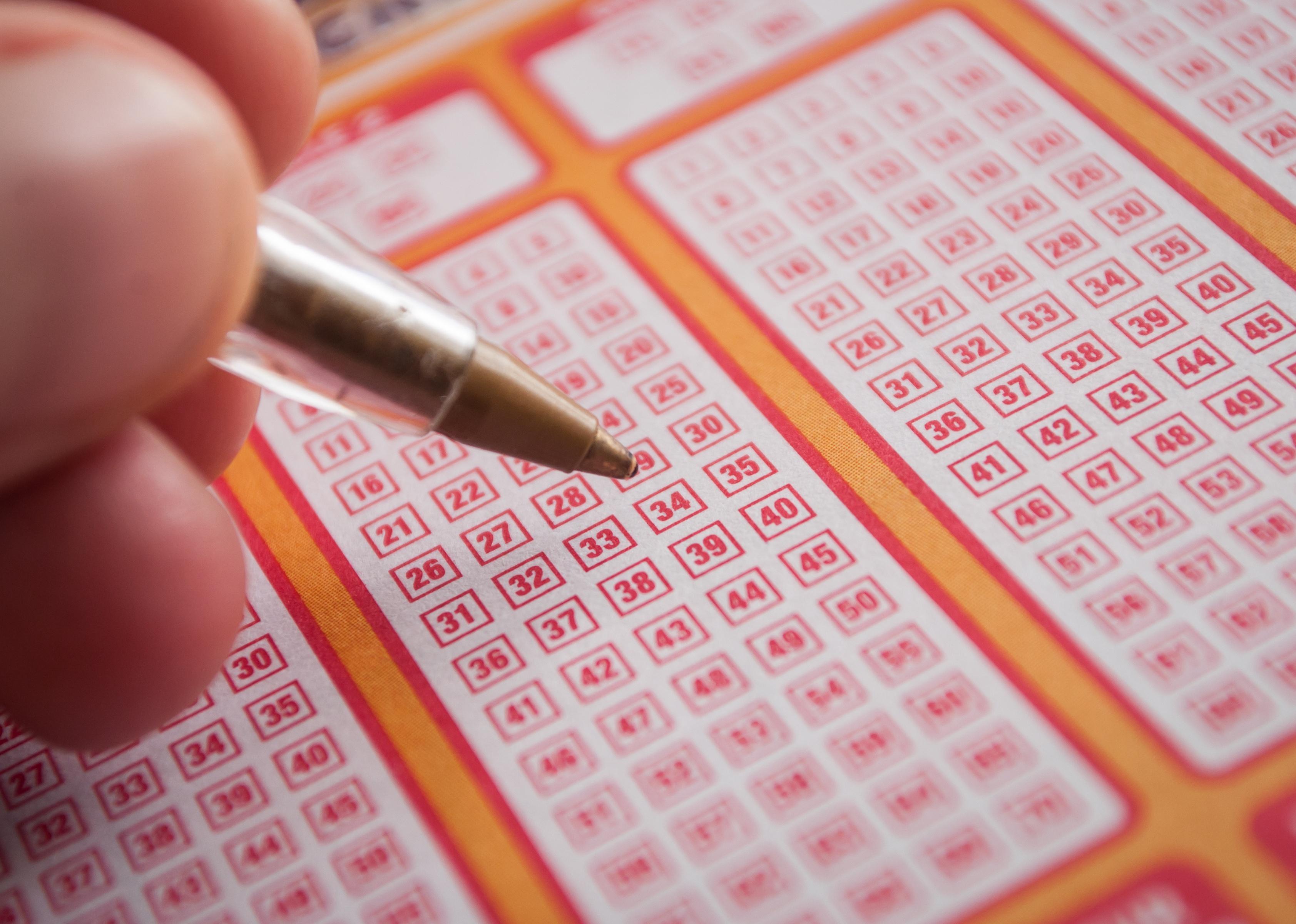 Closeup of a hand filling in a Keno grid.