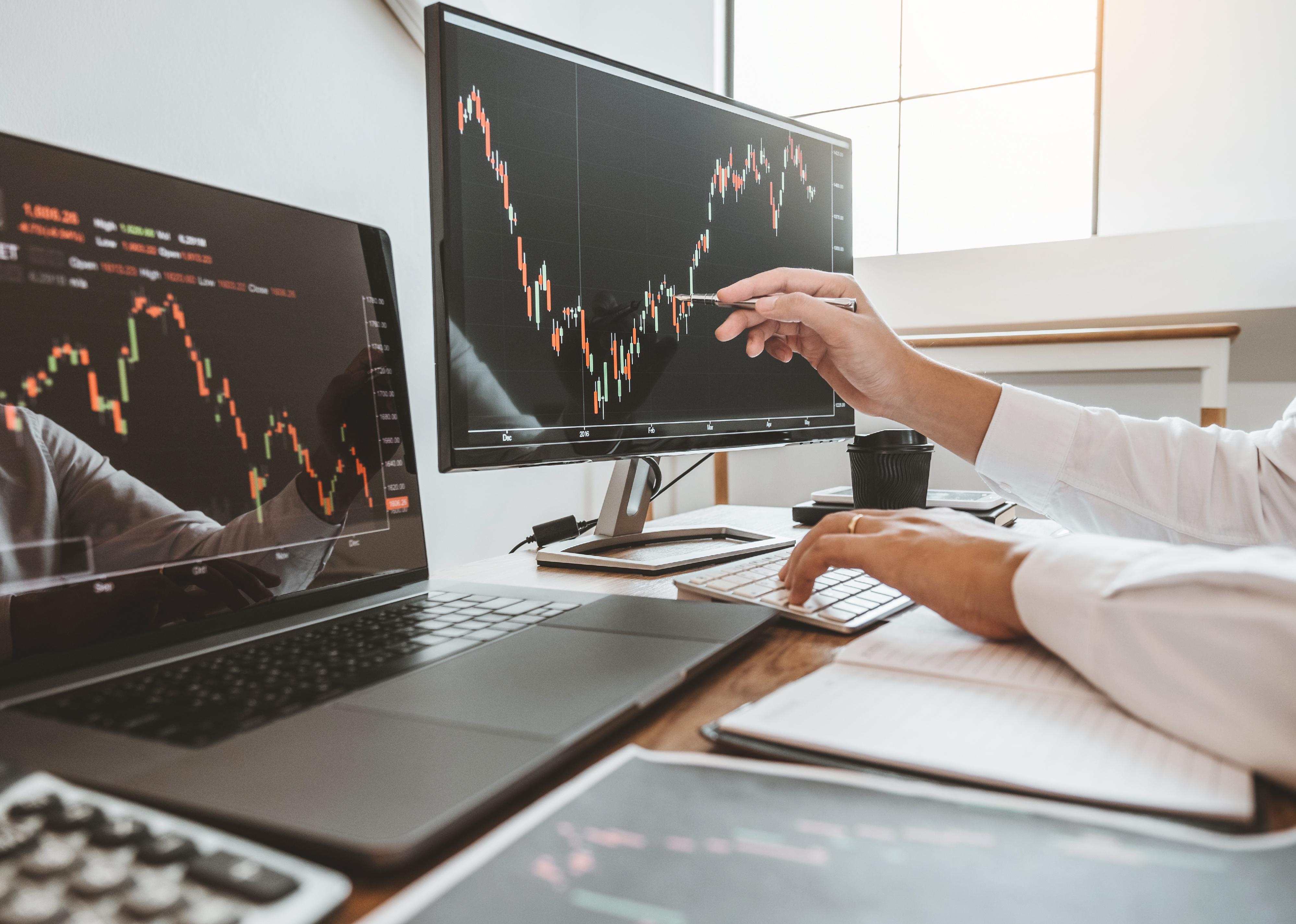 Man pointing to and analyzing stock market graph.