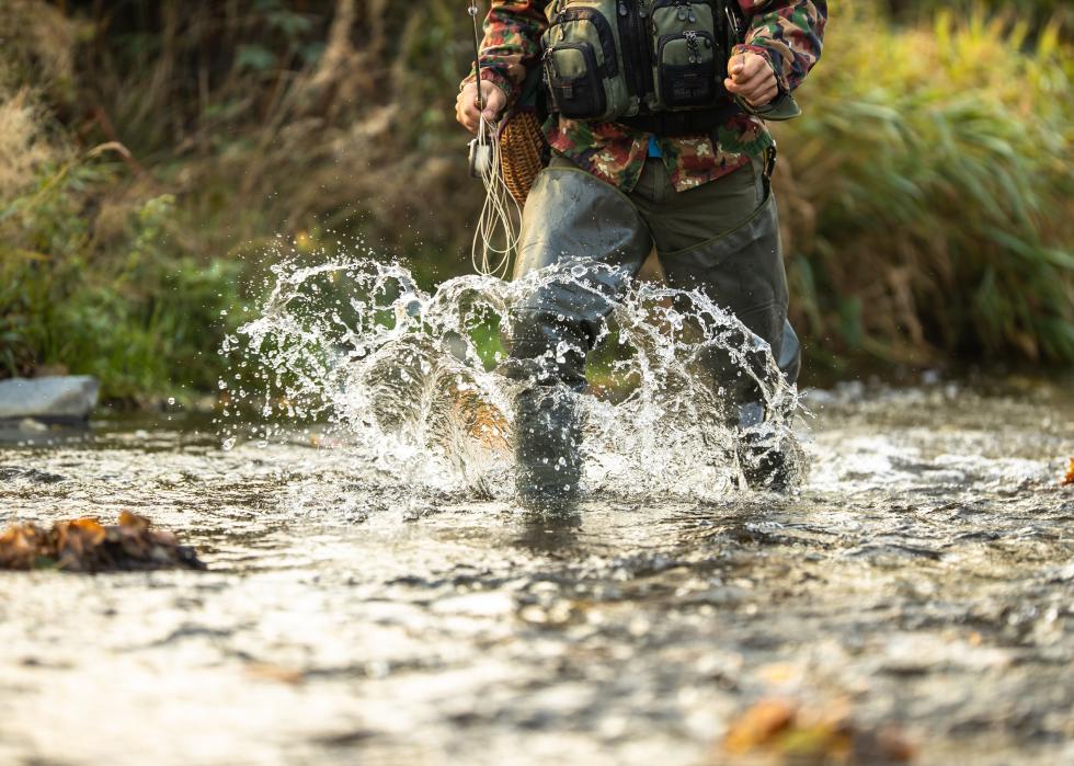 Close-up view of the hands of a fly fisherman holding a trout.