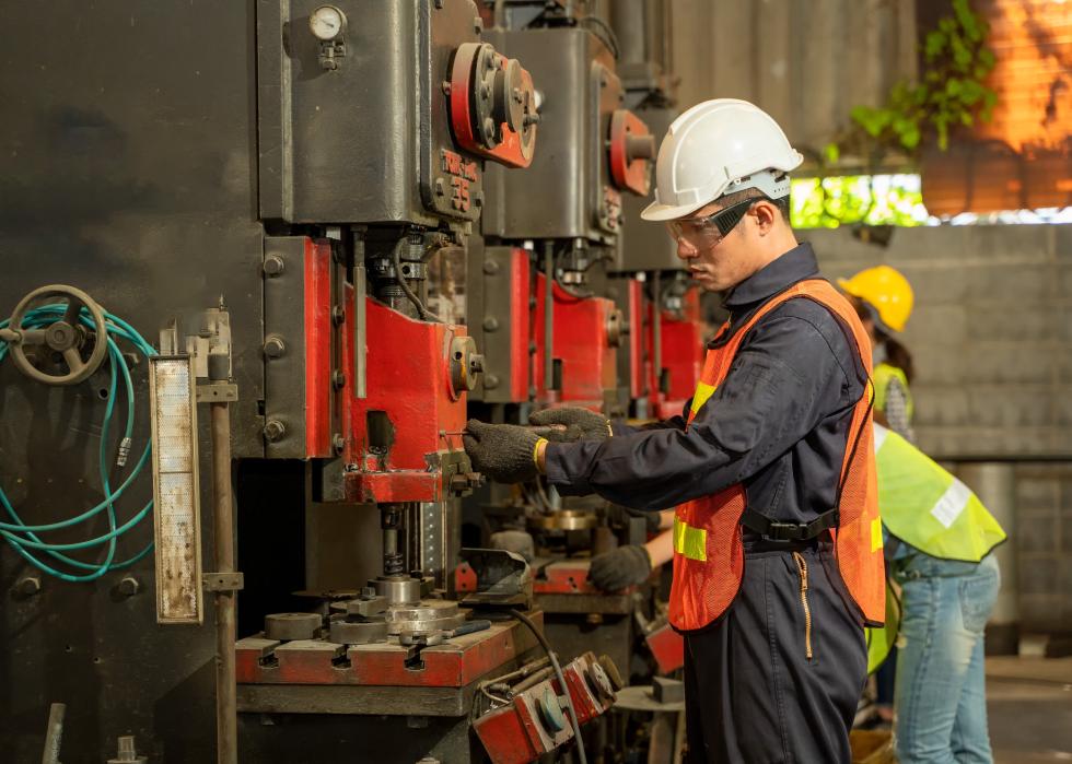 Technician in safety gear working with a vertical milling machine