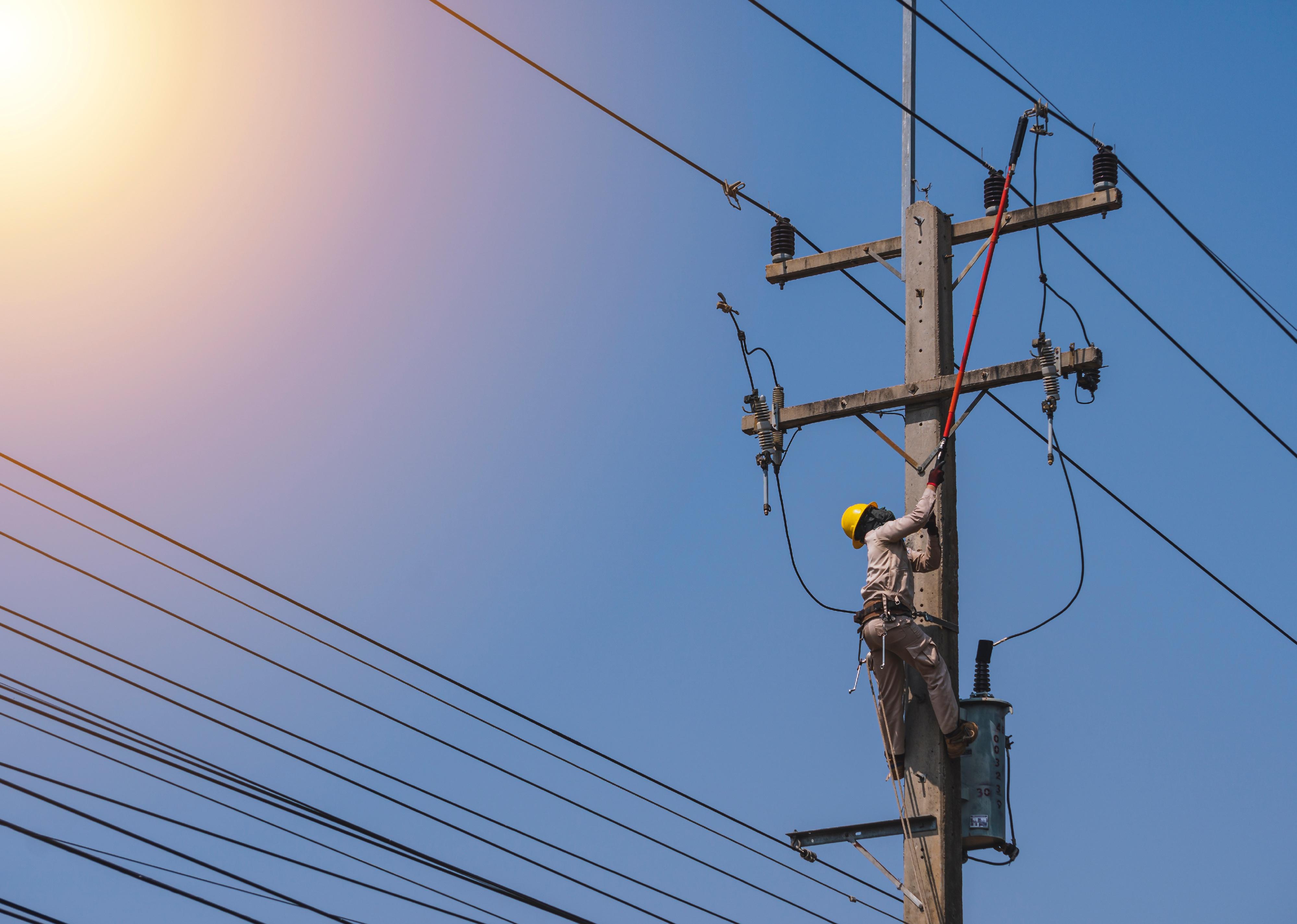 Lineman uses insulated tool to open the connection of a transformeribution system.
