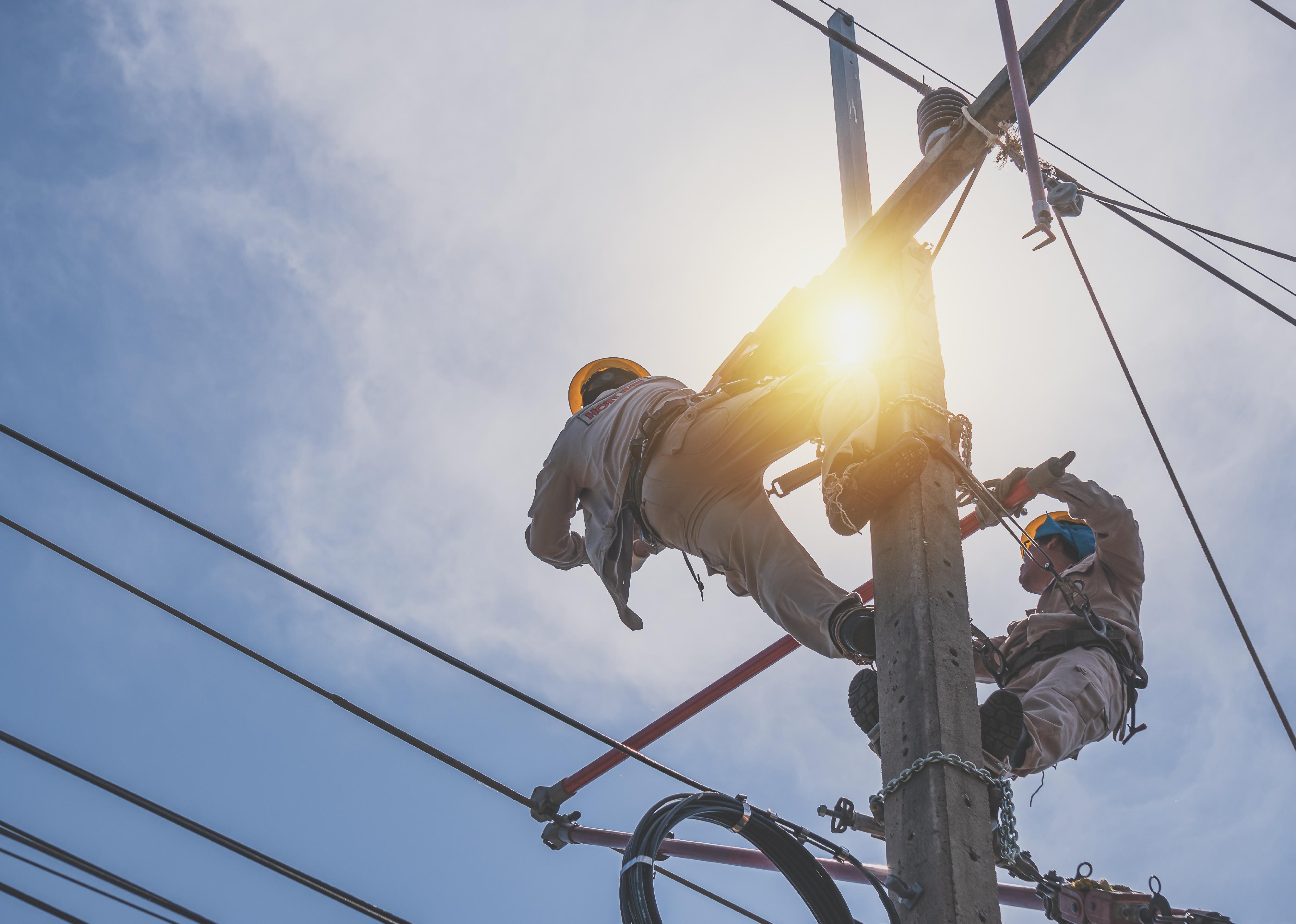 A power lineman is replacing the damaged insulator.