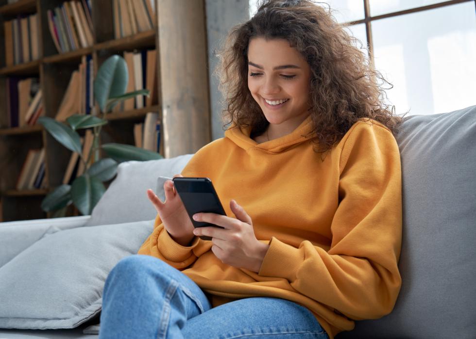 Smiling young woman using mobile phone