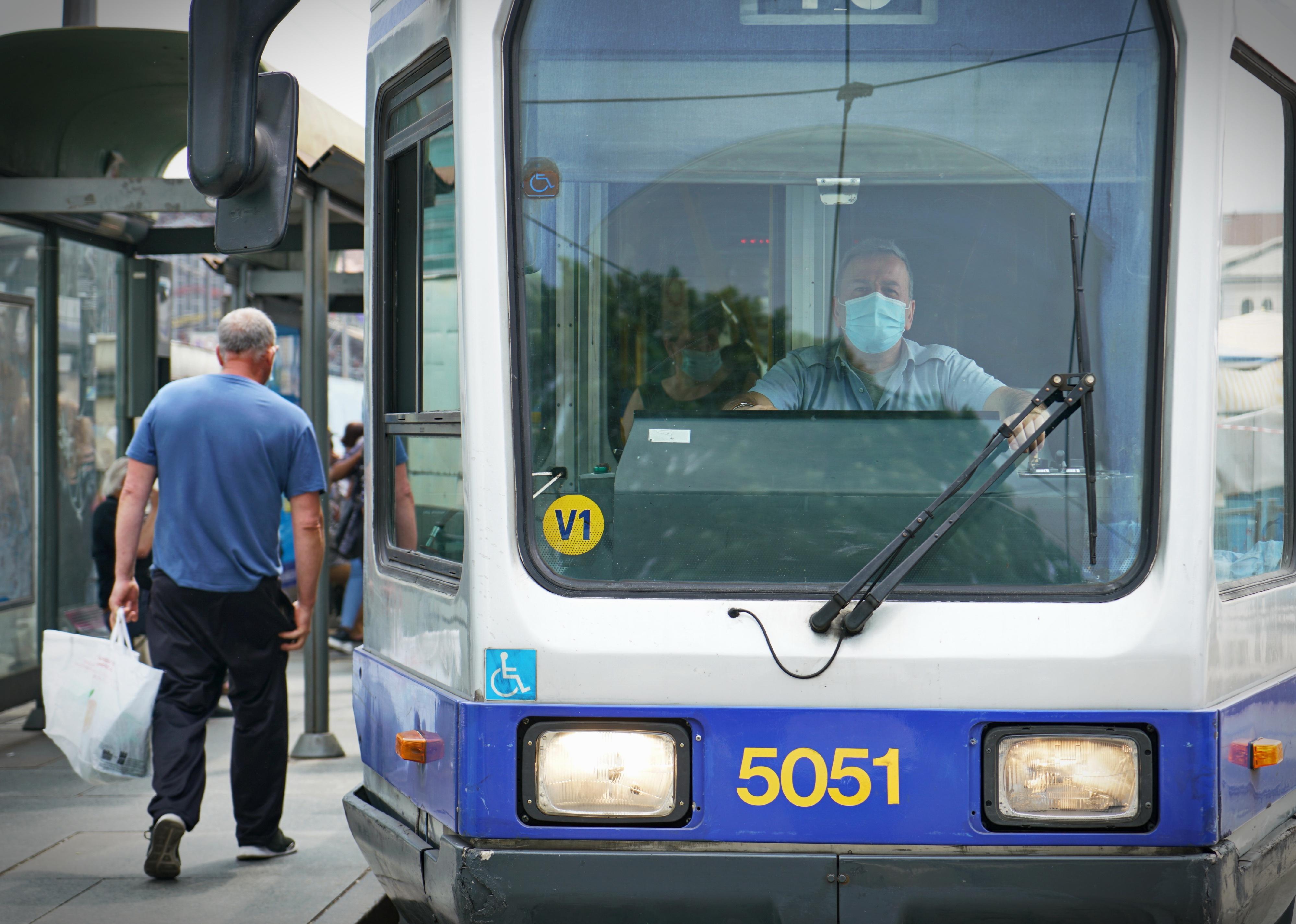Tram car driver behind operating panel.