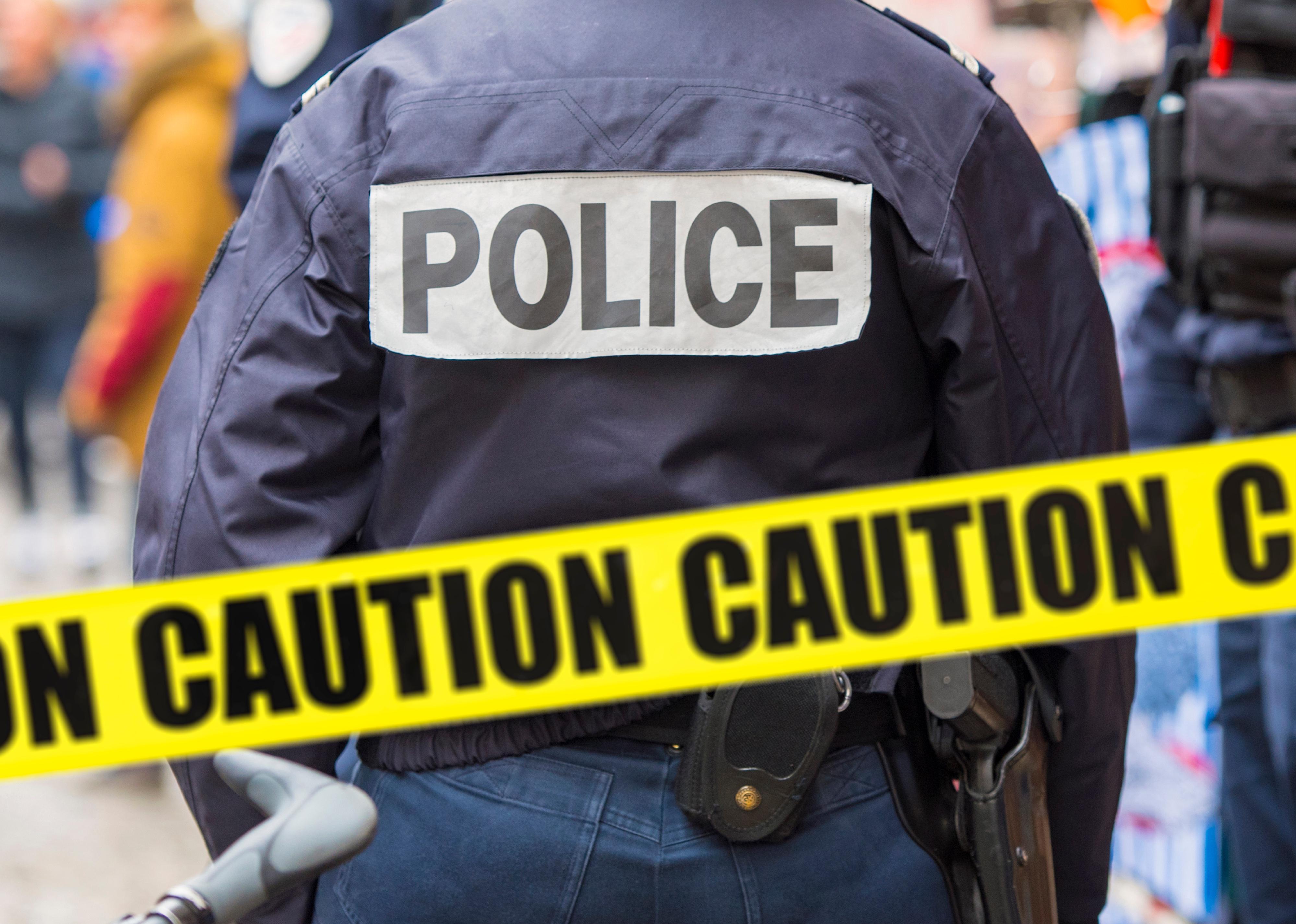 Police man and yellow crime scene tape.