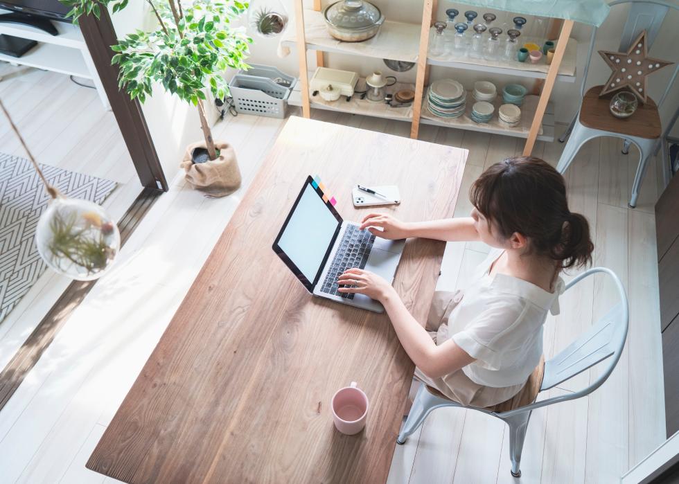Woman doing work with laptop at table at home