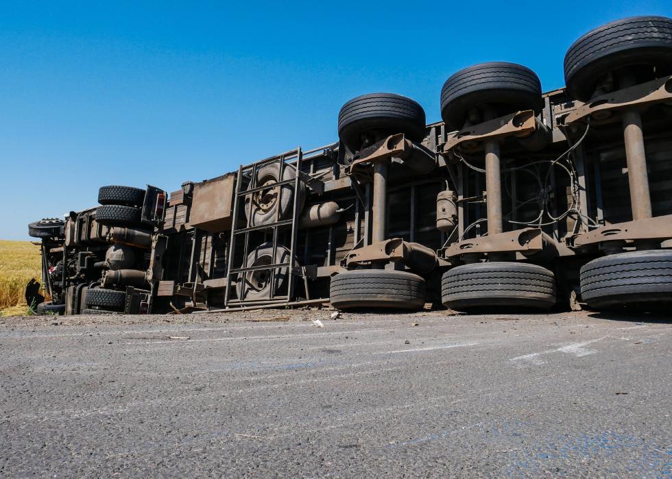 Upside down trailer truck with semi-trailer on the side of the highway
