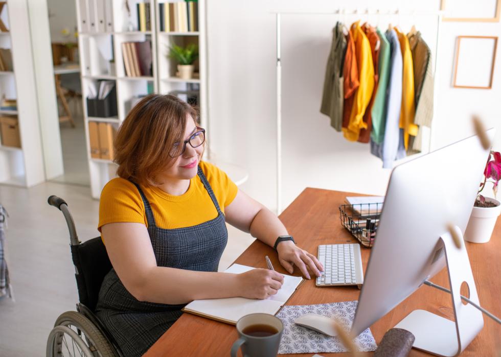 Young female in wheelchair working on laptop