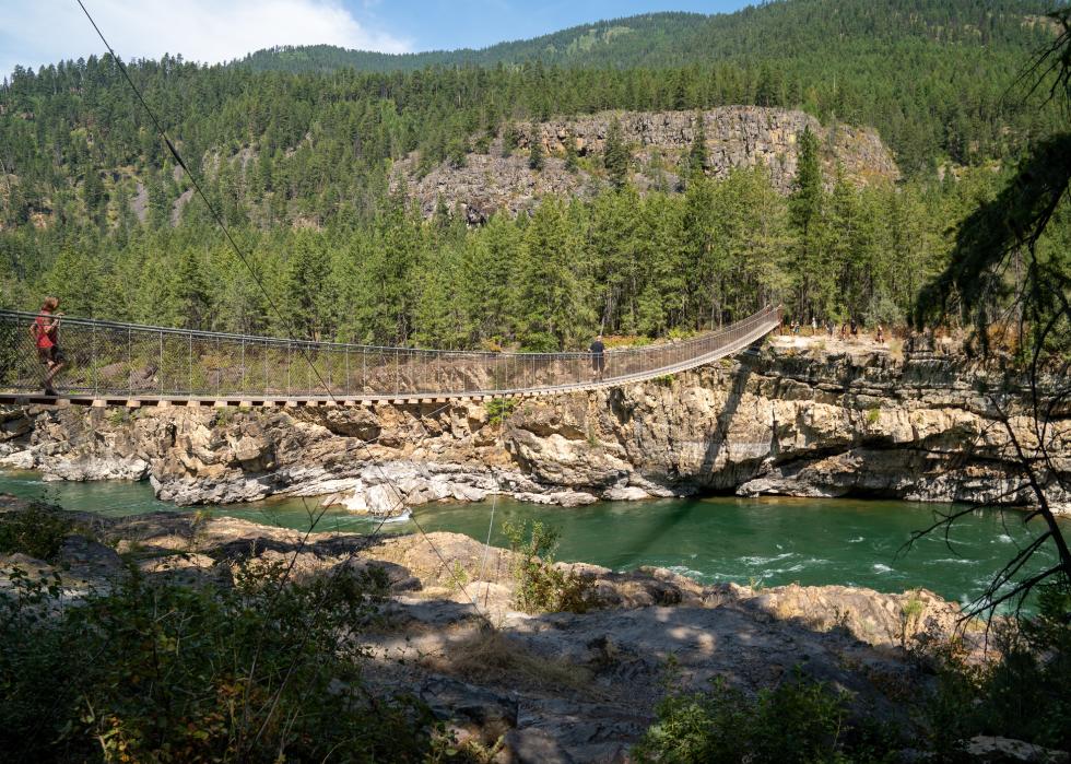 Tourists cross the bridge along the Kootenai River in the Kootenai National Forest.