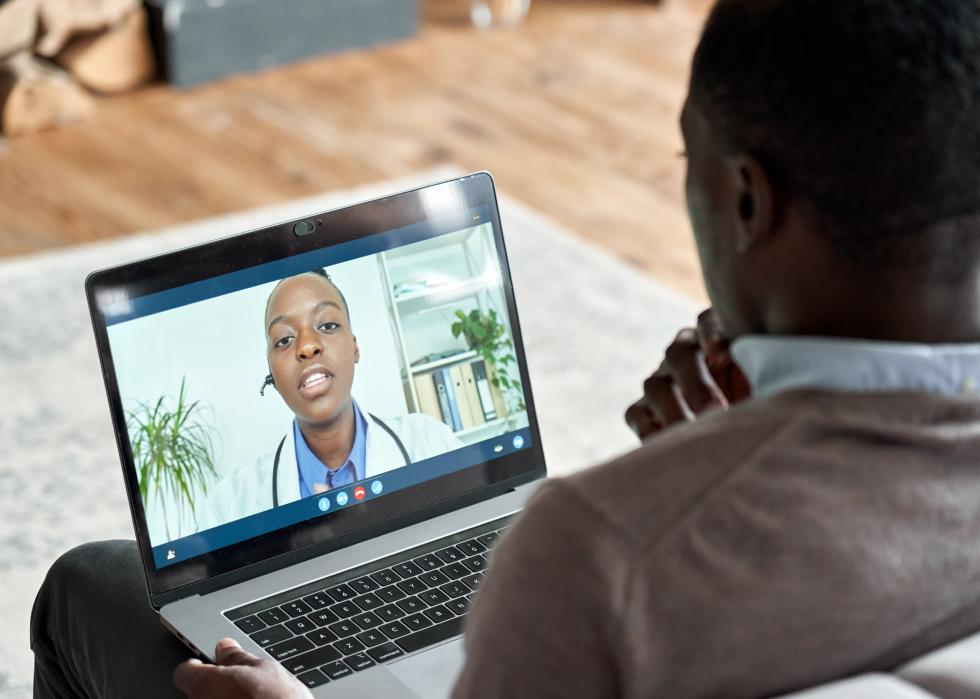 Male patient on conference video call with female doctor