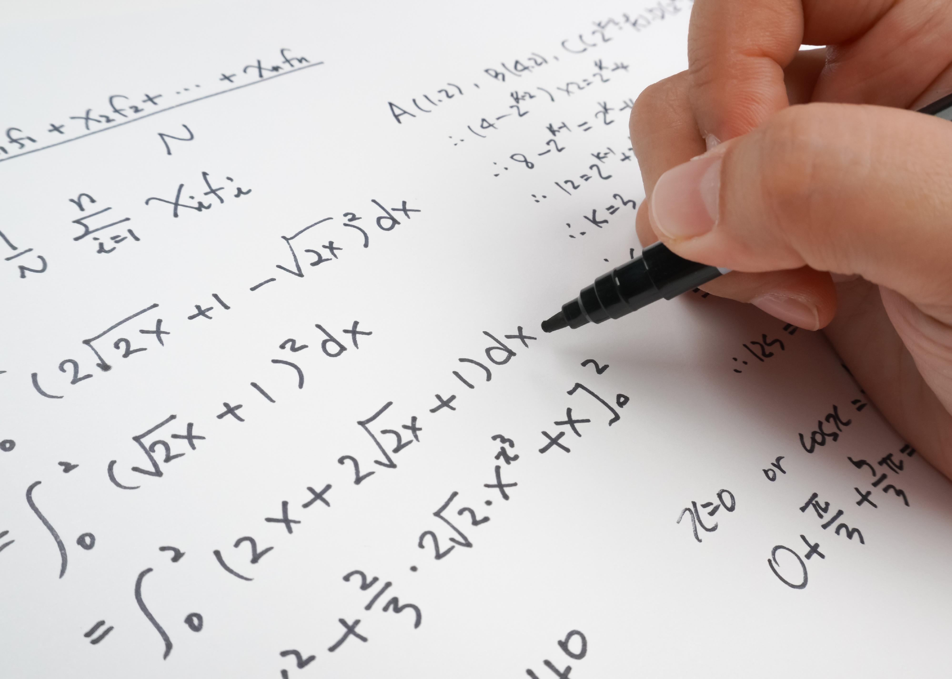 Close up of calculus work and hand holding pen