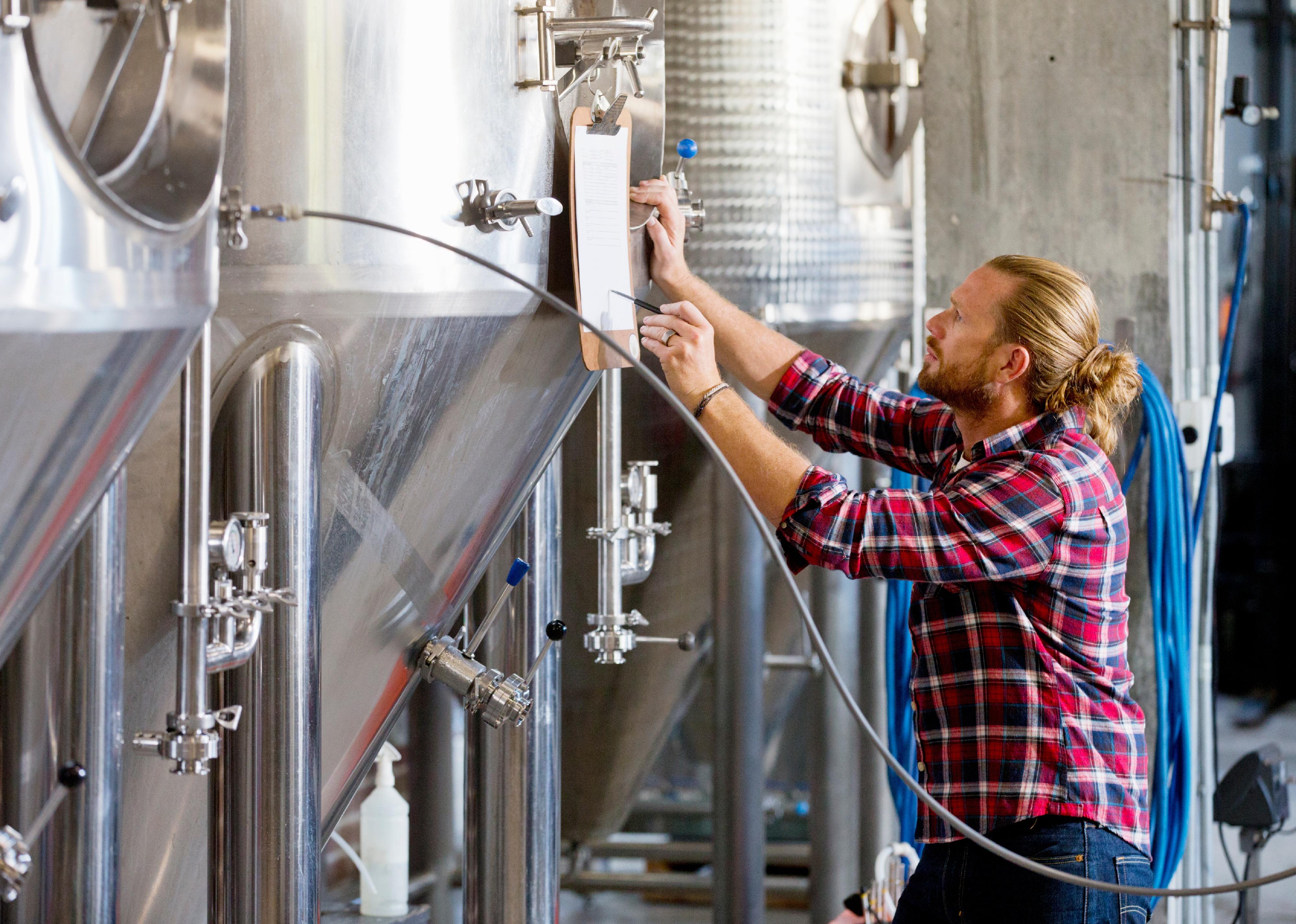 Brewery worker checking fermentation process