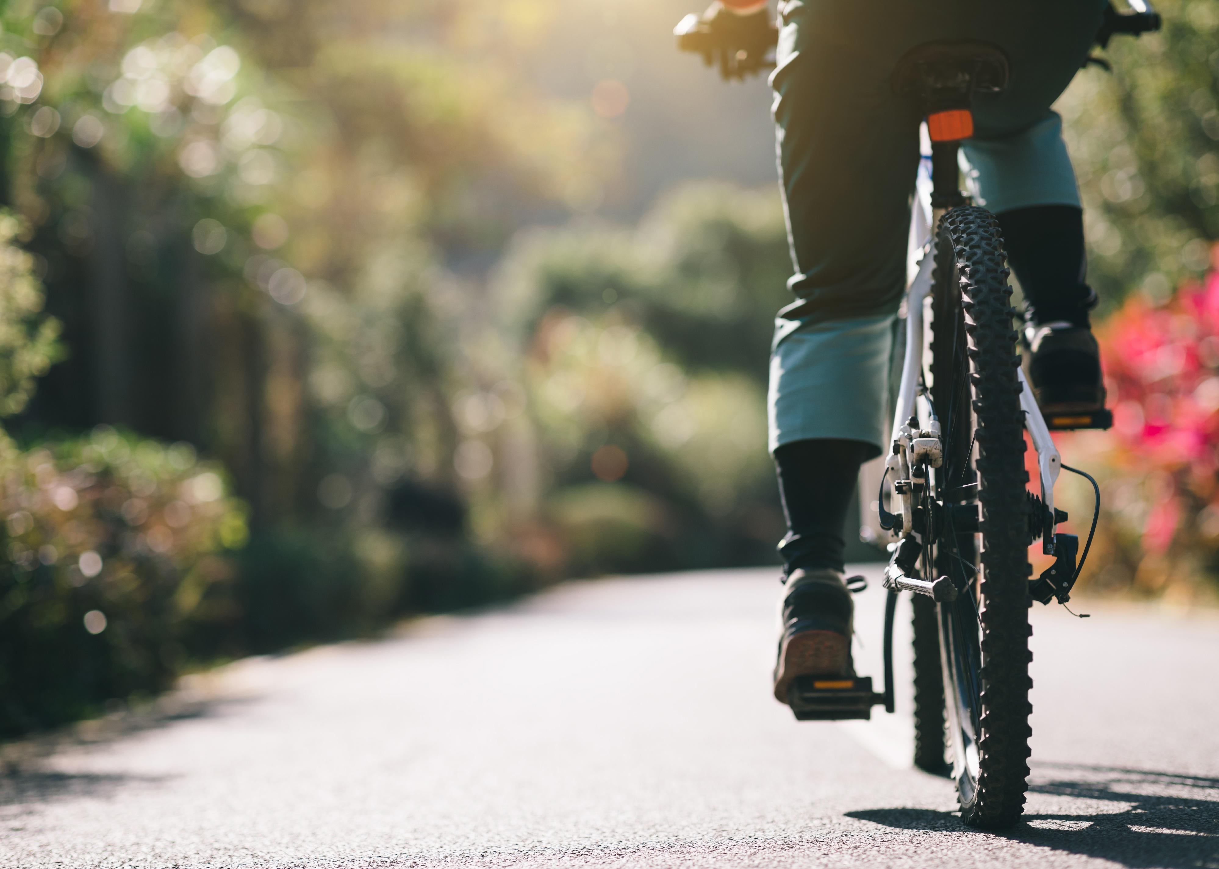 Woman riding a bike on a park trail.