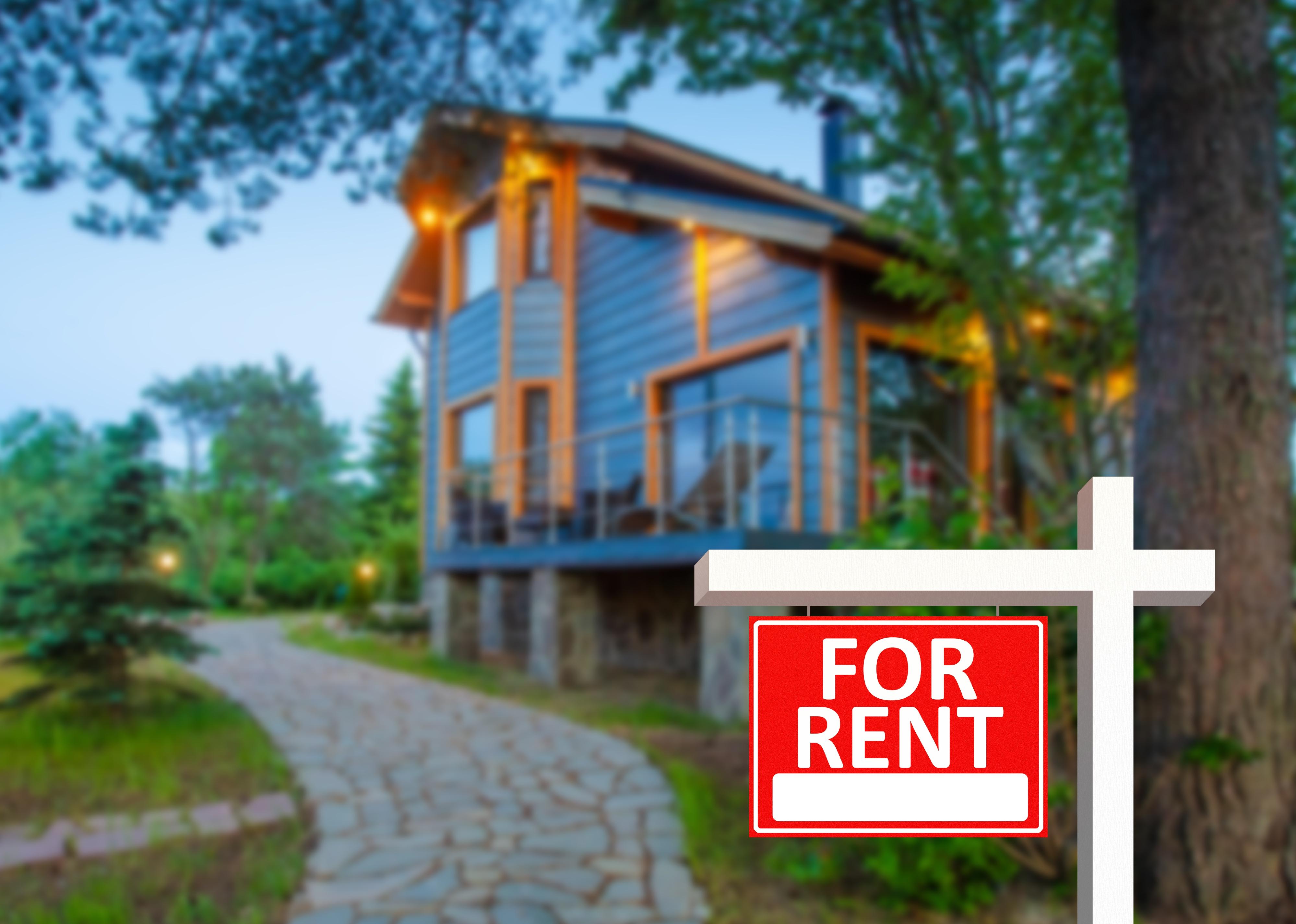 Red for rent signin front of modern rustic cottage.