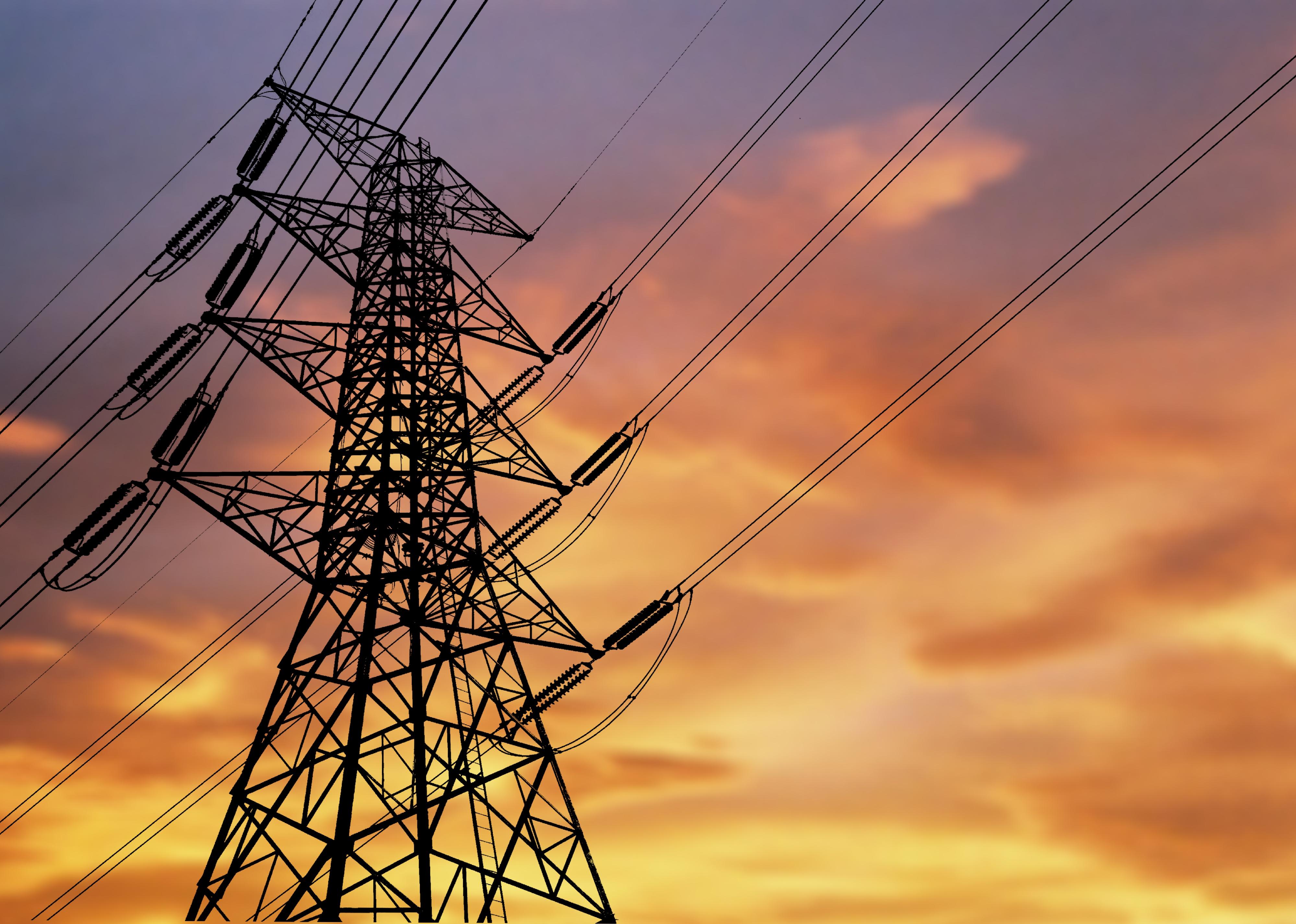 High-voltage power lines at sunset.