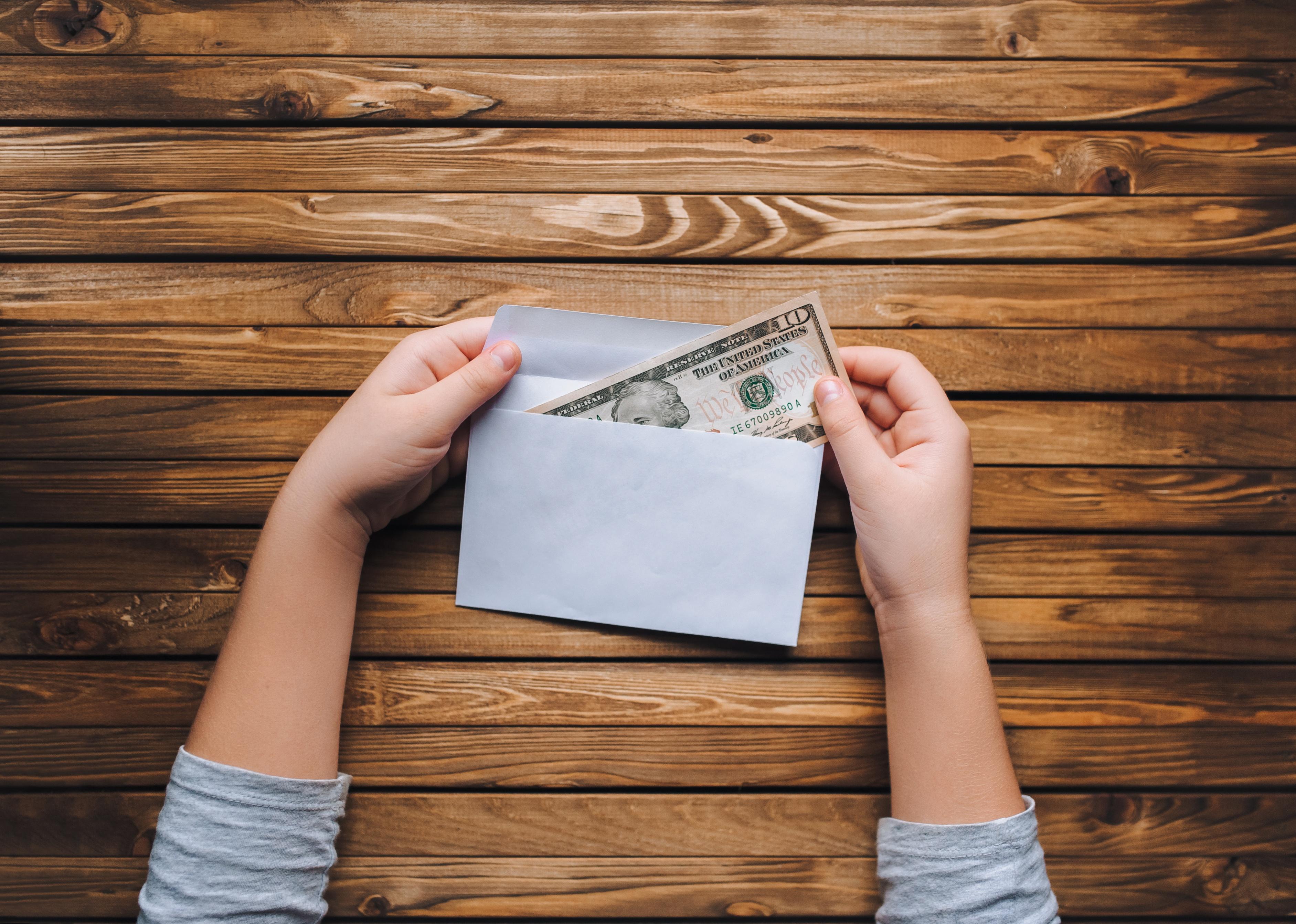 Close-up of hand taking money out of envelope