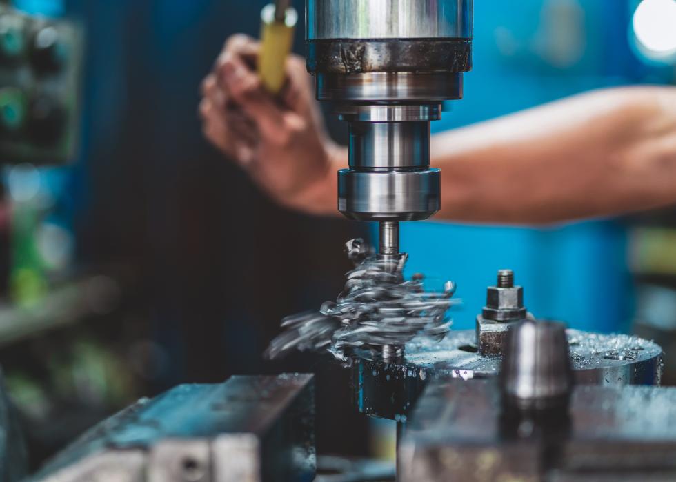 Close up of machinist hand working with milling machine