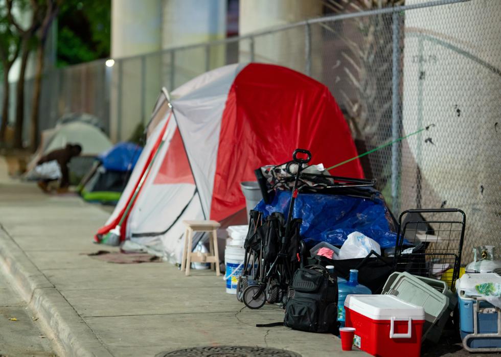 Tent and supplies set up on a sidewalk.