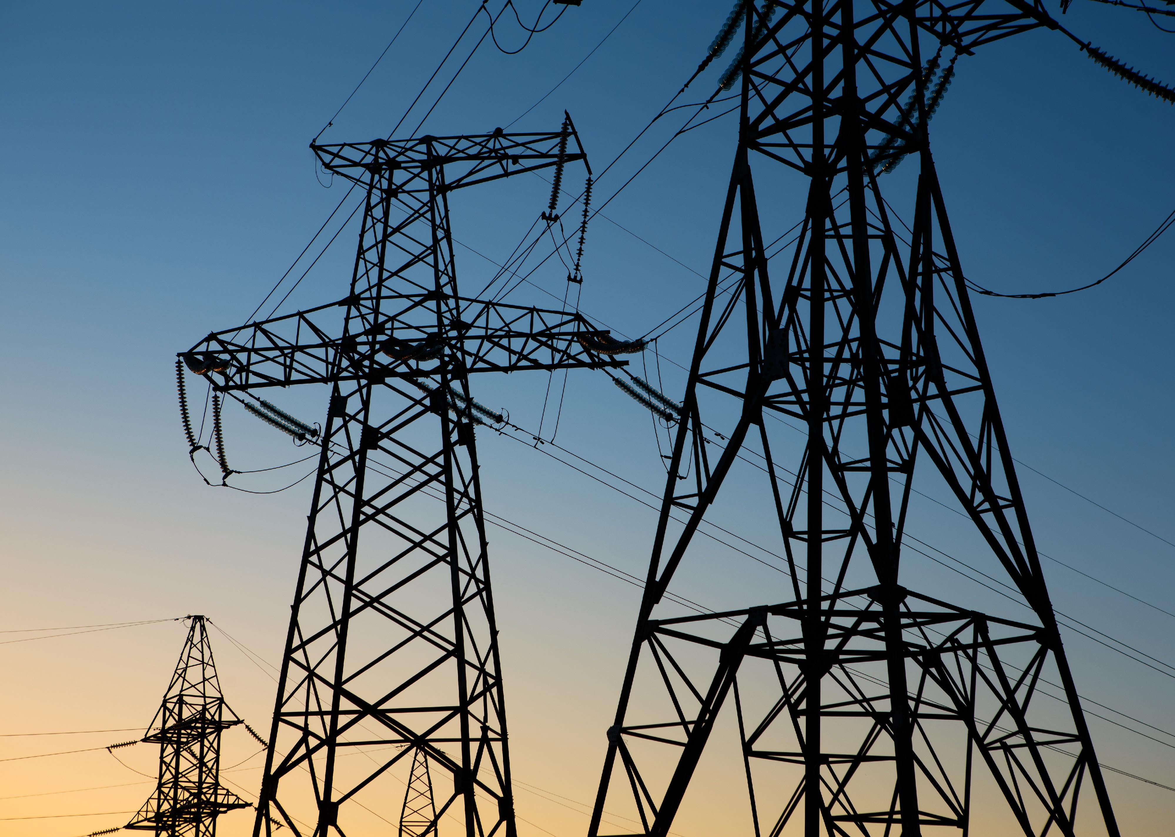 Silhouette of a high voltage electric tower at sunset.