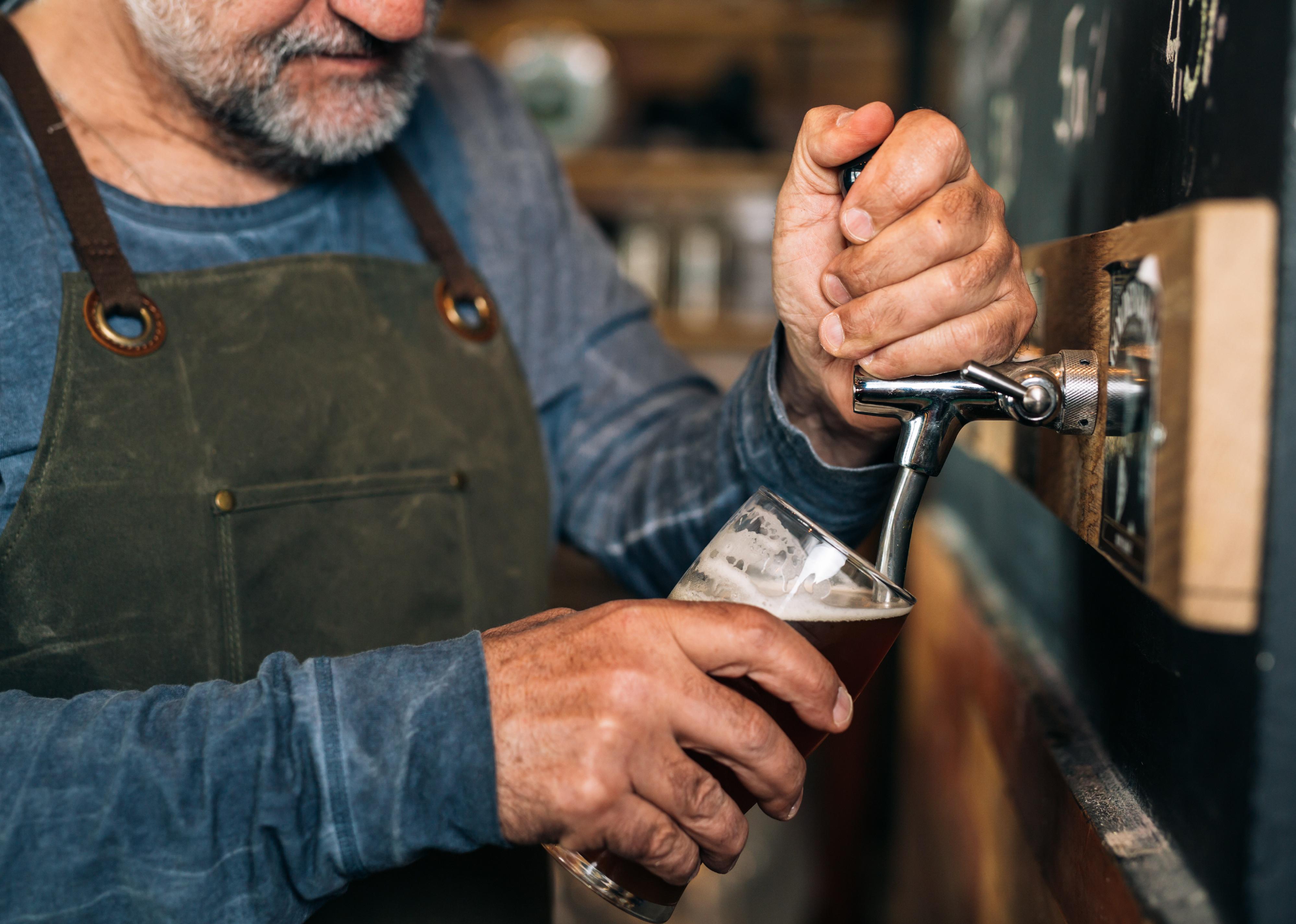 Closeup of barman serving beer in pub