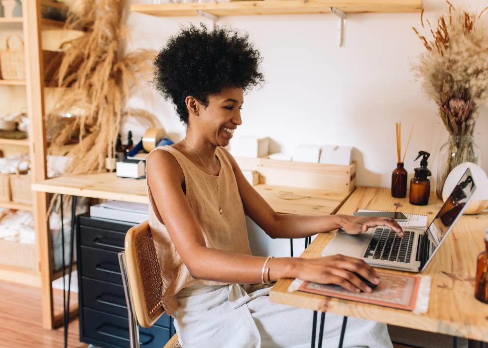 Jewelry artist working on laptop in studio