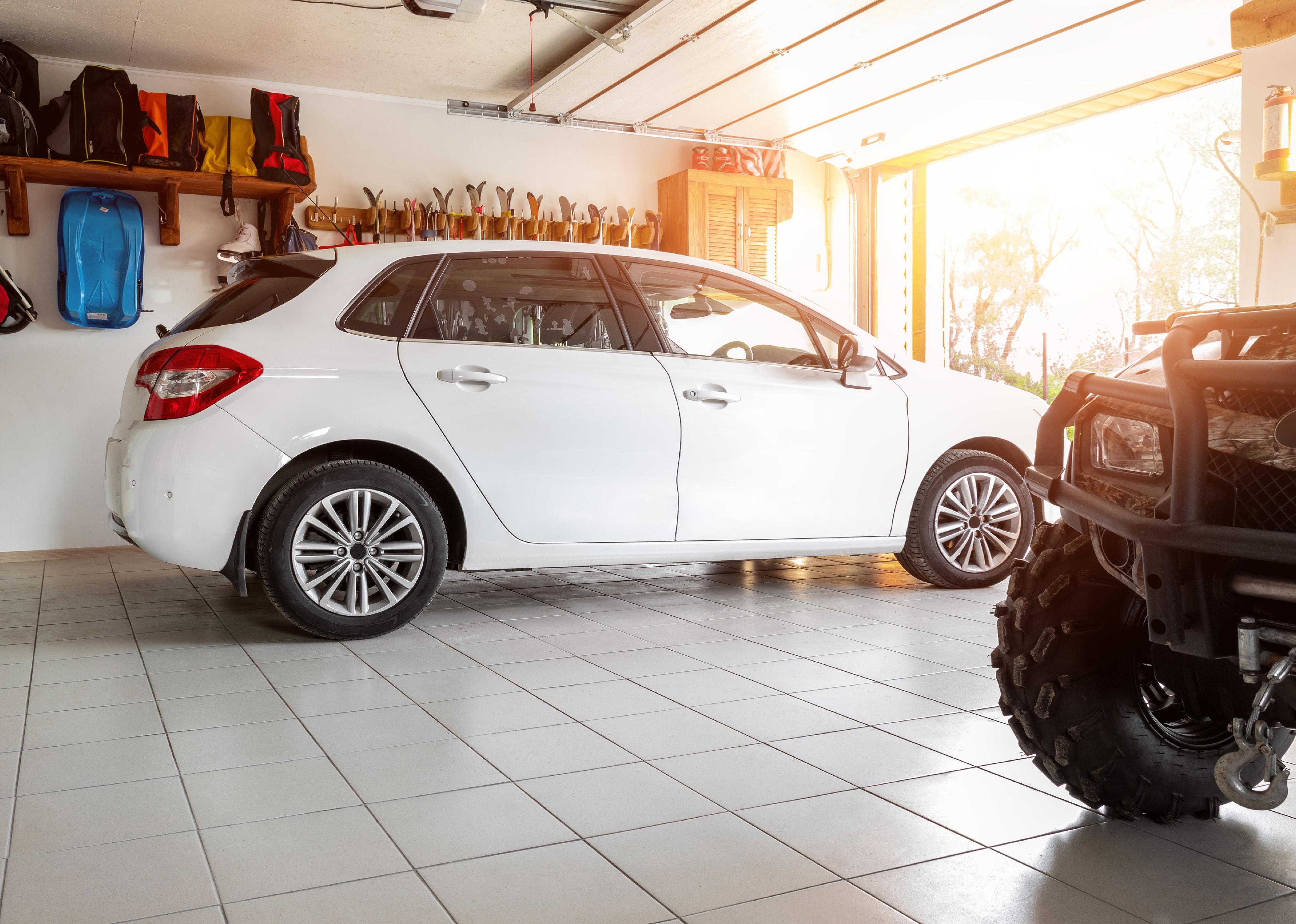 Suburban modern car and ATV in double garage interior.