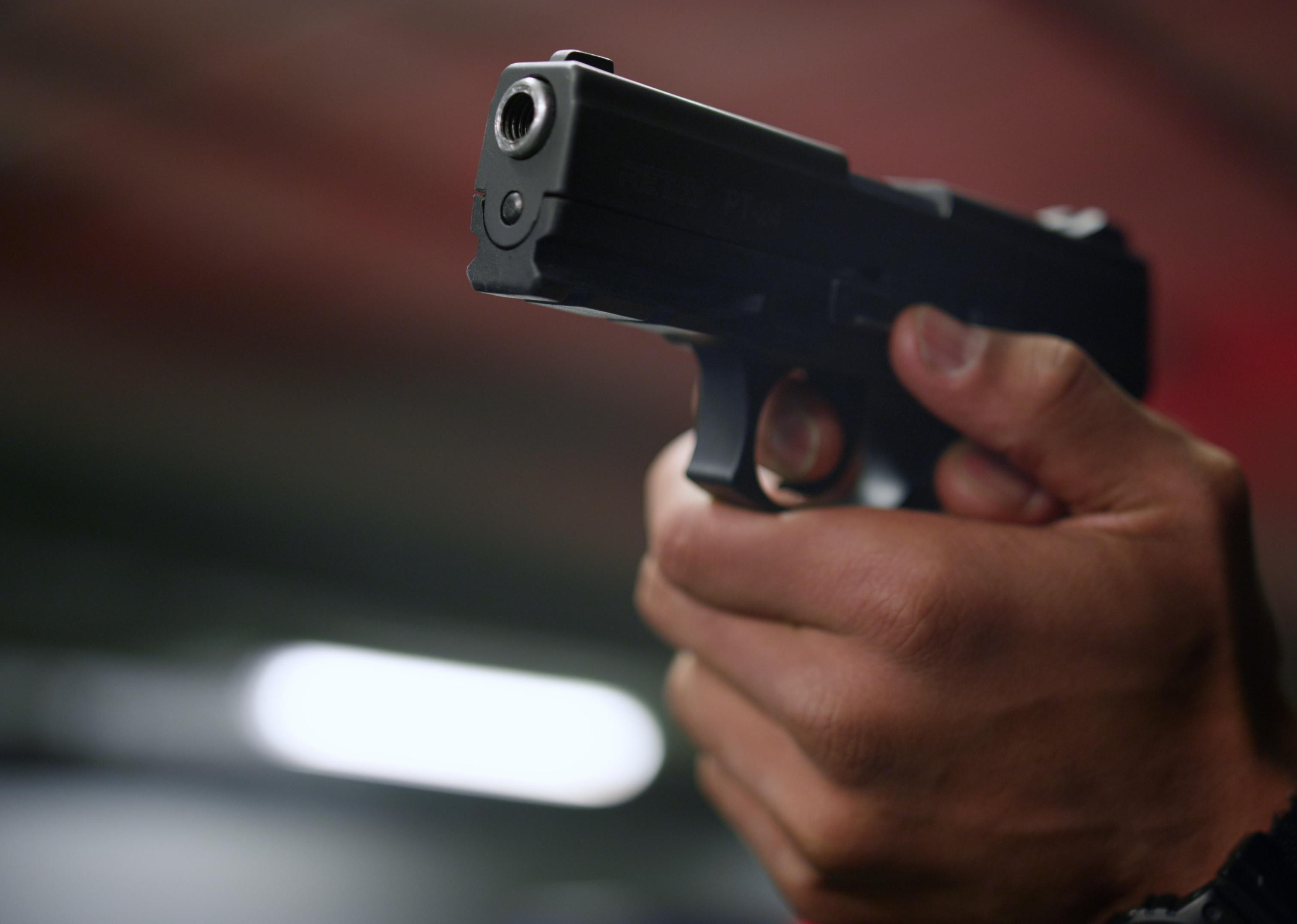 Closeup policeman hands aiming gun.